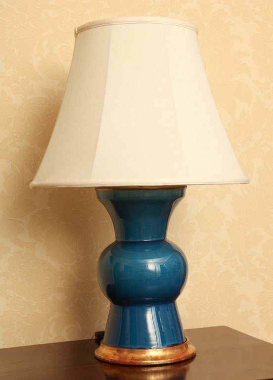 These shapely 'Gregory' model, sapphire blue ceramic lamps are by Christopher Spitzmiller. Featuring a brass double socket cluster, 23K gold water gilt base and ivory silk shades.