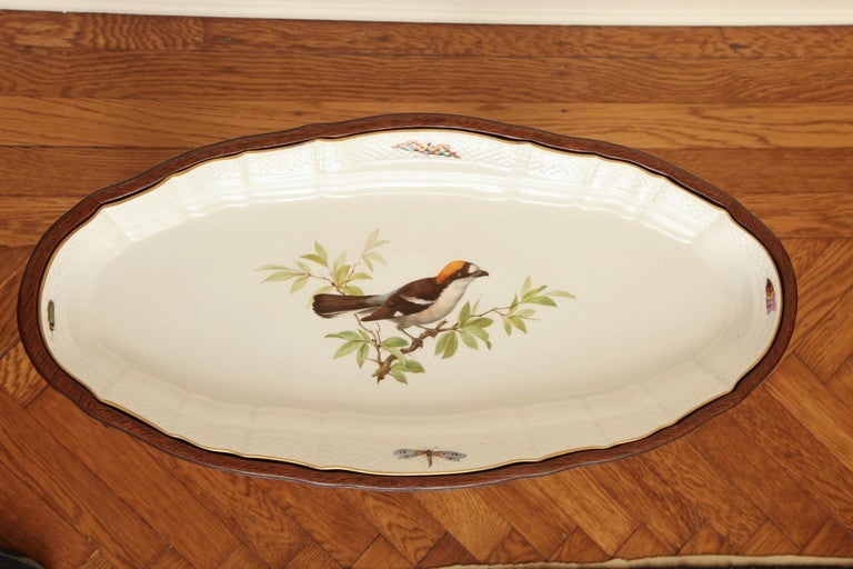 This is a charming elongated mahogany oval table with inset porcelain dish depicting a bird perched on a tree branch with dragonflies and various insect along the basketweave-molded rim. Bearing 19th century Meissen crossed swords mark on underside.