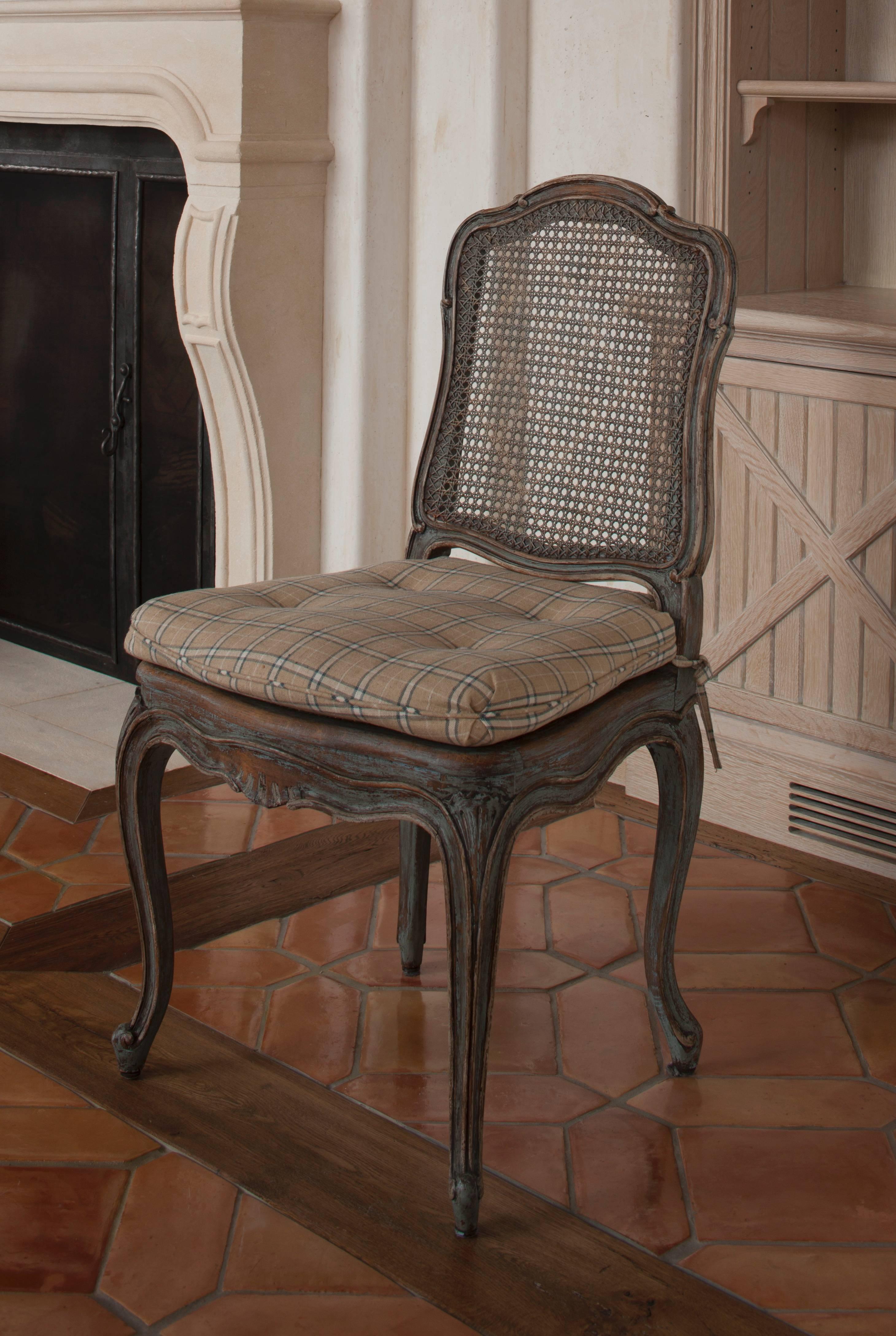 Beautifully made, hand-carved set of chairs after a period model.  Each made of oak with antique blue-grey painted finish.  The backs and seats caned.

Supplied by David Easton for a private residence.
