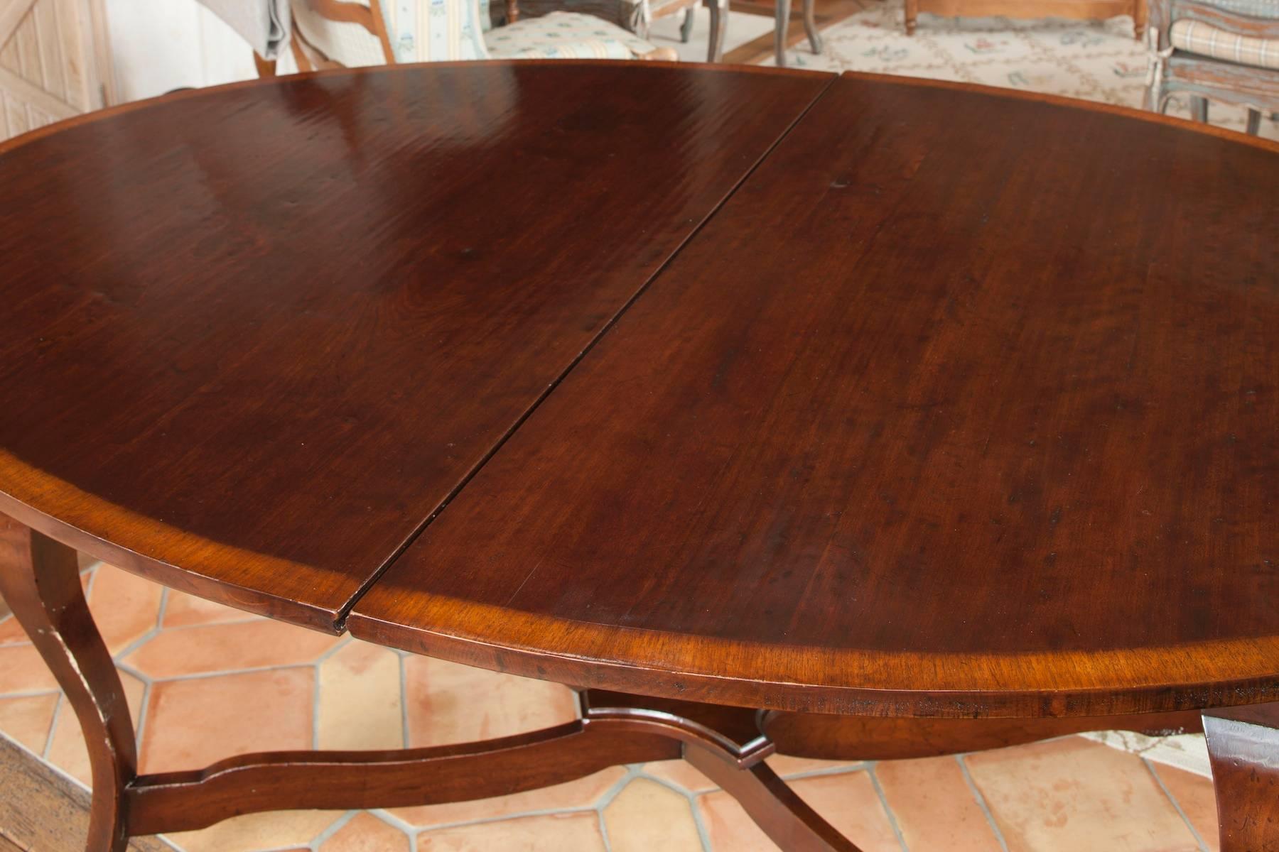 Supplied by David Easton for a private residence. Hand-carved table with cherry finish mildly distressed for an antique effect. With contrast banding along edge and raised on cabriole legs joined by a gracefully arching stretcher. Opens to one