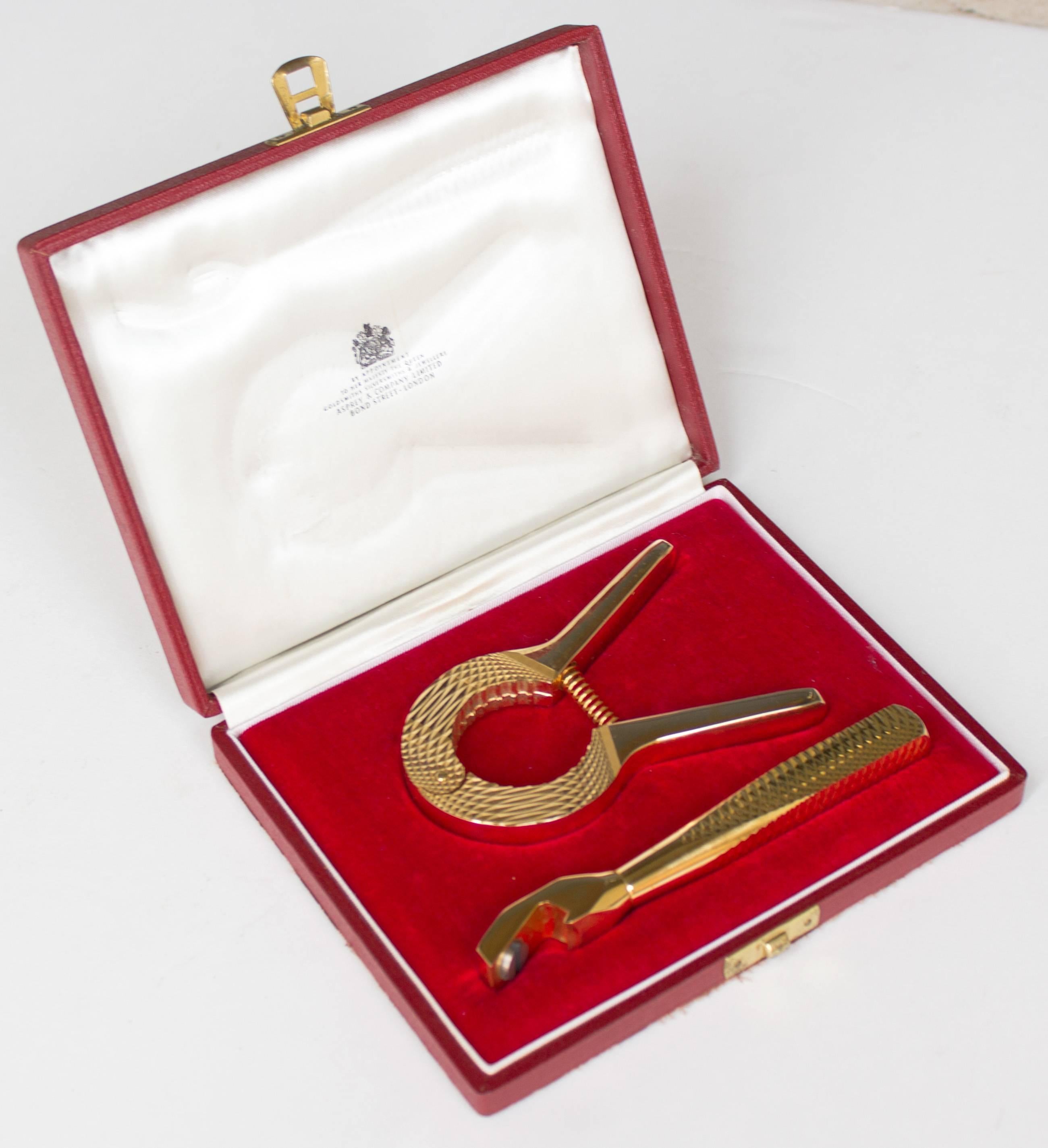 A two-piece bar tools set from Asprey, one of the United Kingdoms oldest premier designers of jewelry and luxury goods. Each piece is gold plated and textured in a diamond pattern.

Set includes a bottle opener and champagne cork remover,