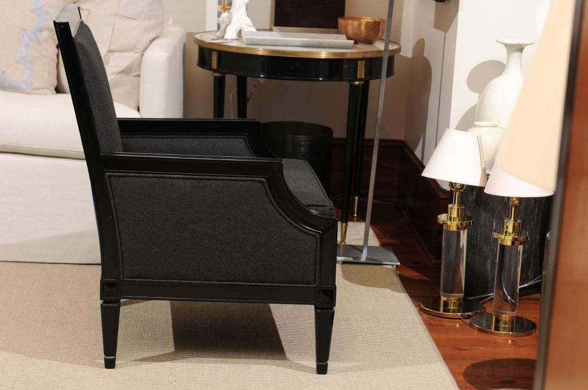 Neoclassical ebonized library chair having tailored backs over loose cushions all raised on chamfered and tapered legs. Having interesting X-form back detail. Measures: H 37
