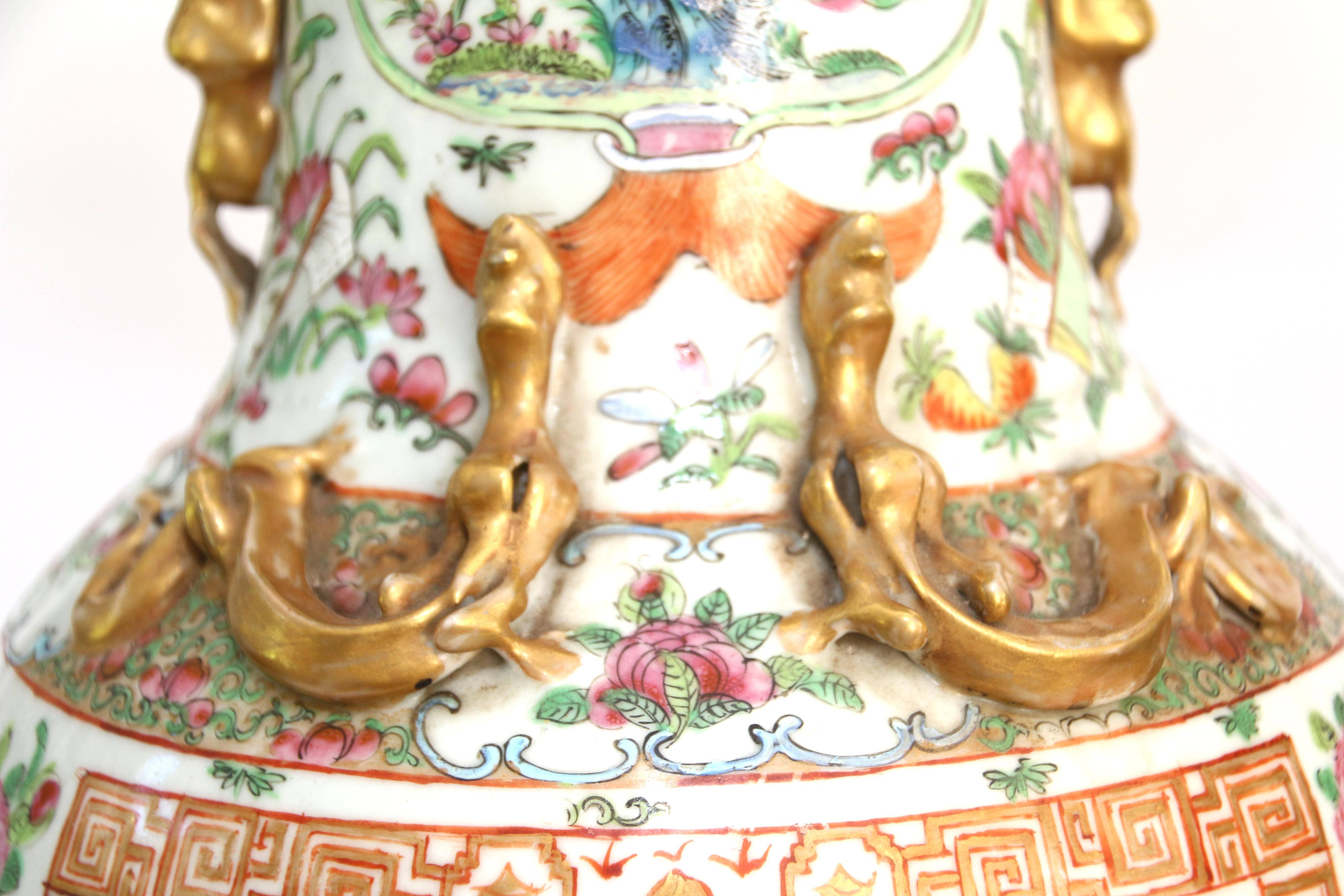 Pair of rose mandarin porcelain vases, China, 19th century, baluster form, with applied gilded foo dogs and dragons to neck and shoulders, and all-over decoration of polychrome enamel medallions with figural scenes and flowers and butterflies,