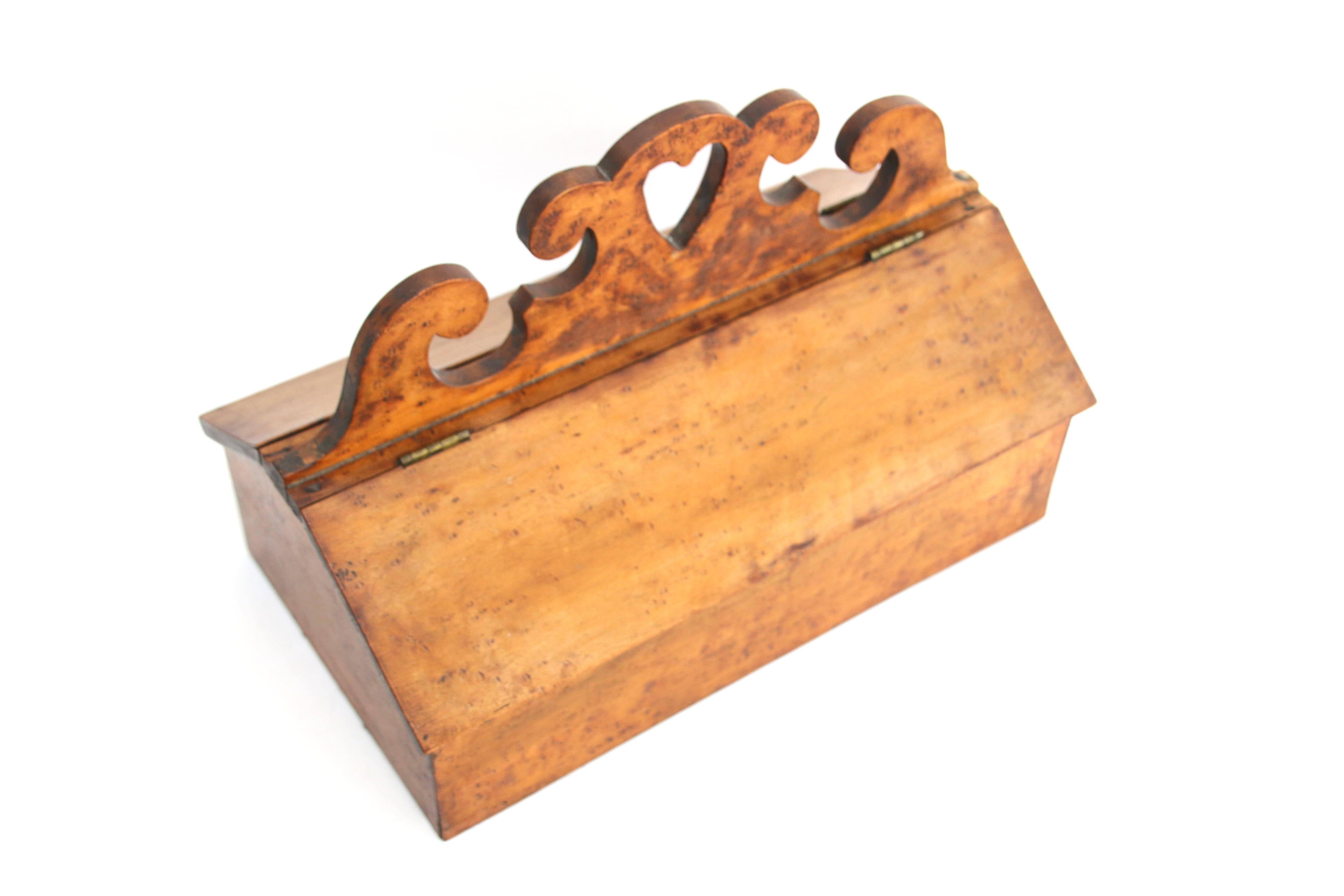 Bird's-eye maple cutlery box with two hinged lids and cutout handhold heart flanked by terminal scrolled edges. Wonderful honey patina. 

Pennsylvania, early 19th century.