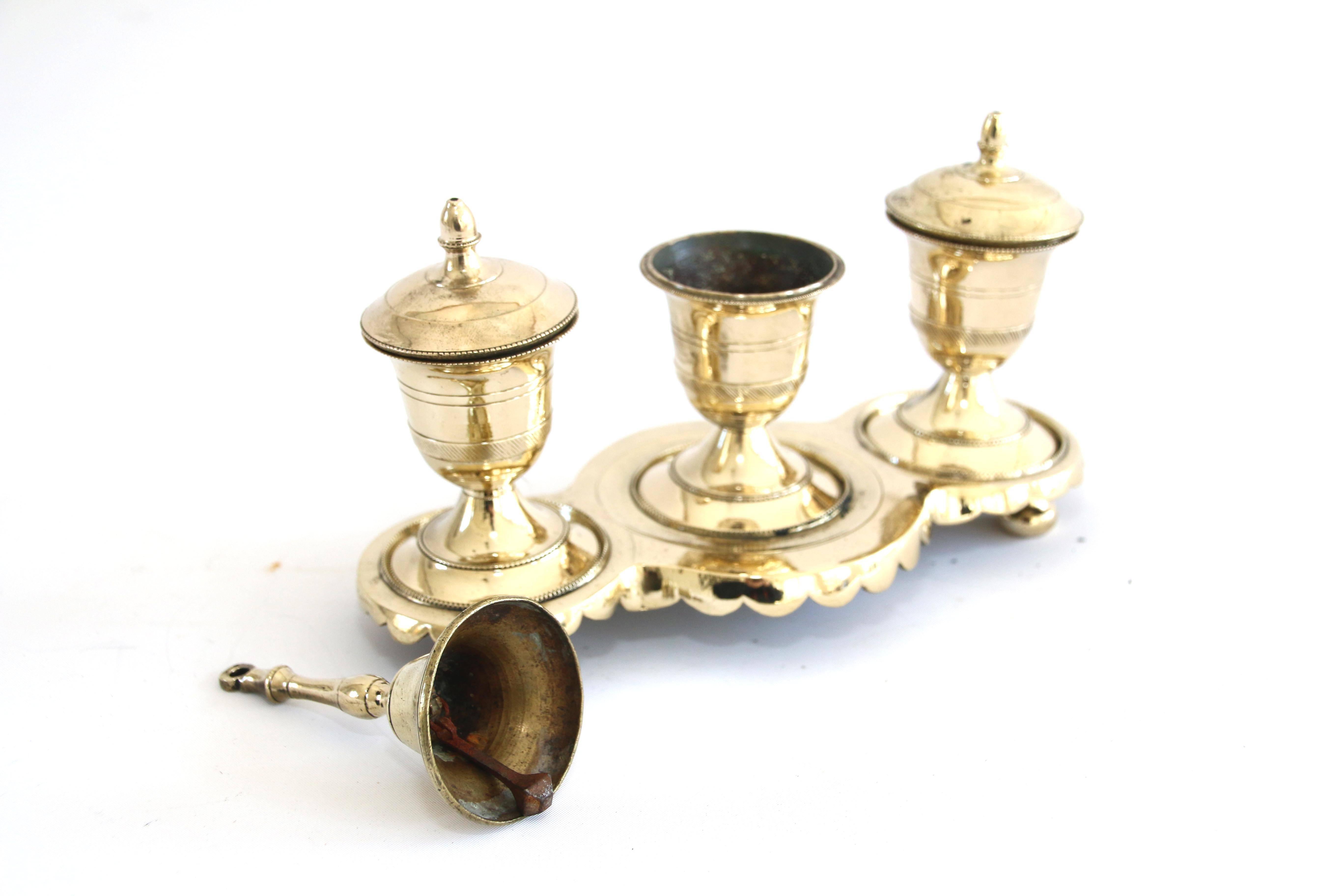 Made in Spain for export in the 18th century, this brass Standish possesses 3 urn-form vessels comprising 2 ink and sealing wax containers, a pounce pot, and service bell. The tripartite base possesses a shaped skirt.

Late 18th Century

7 ½” H X 8