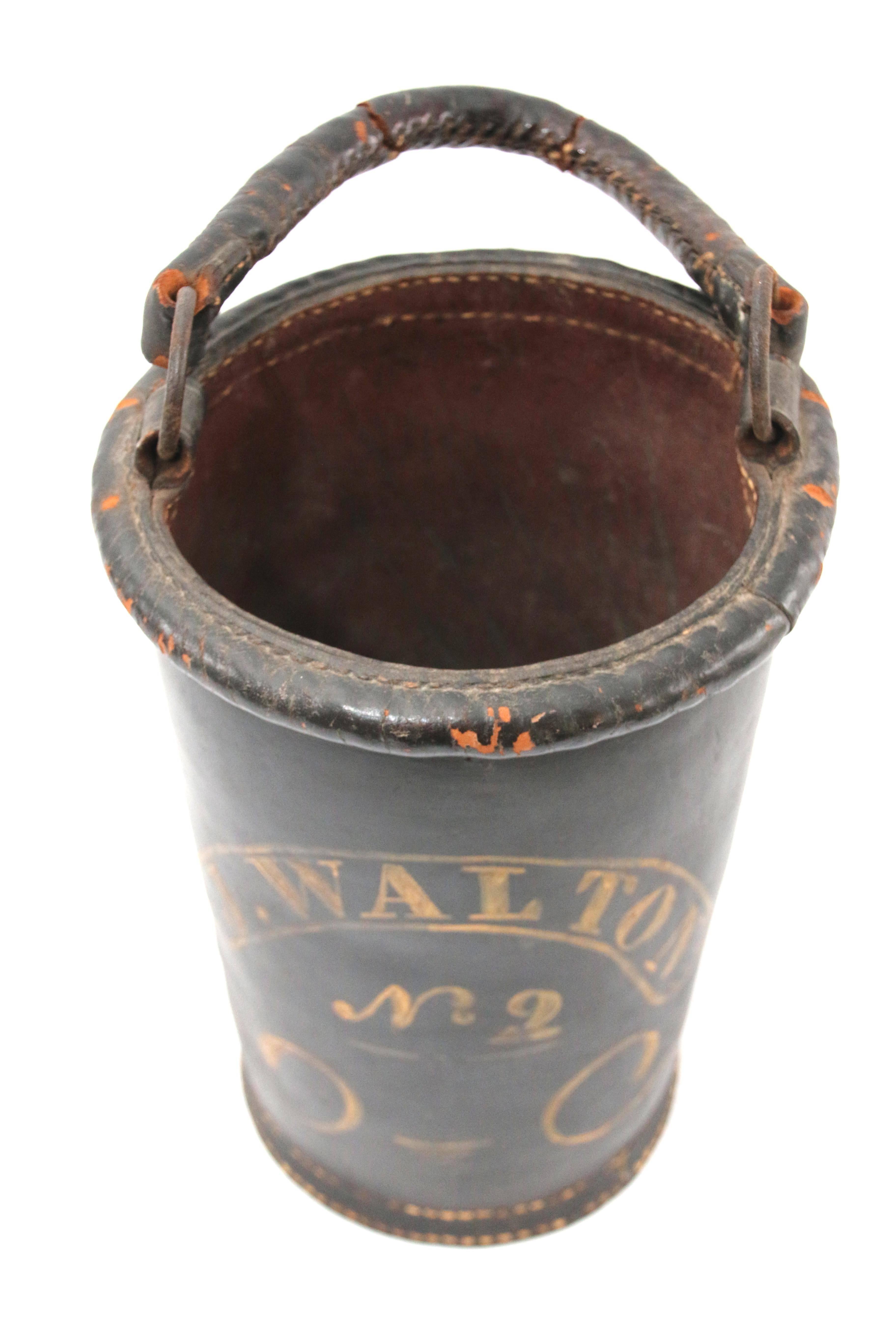 Early 19th century New England leather fire bucket with swing handle.  Painted dark green and yellow inscription - J. Walton No.2 - ; within scrollwork.  Overall height 19.75 inches
