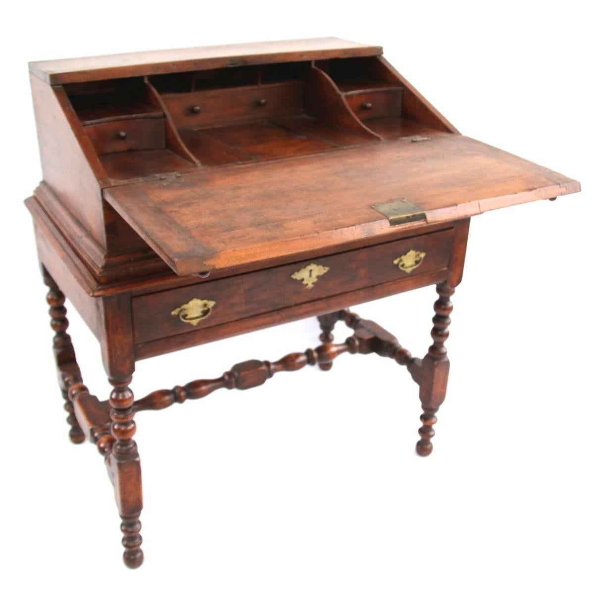 Fine rectangular maple box with hinged writing slope lid opening to an interior with five compartments and three drawers. Interior also features a well with sliding door. Desk projects above a rectangular frame- the frieze fitted with single fitted
