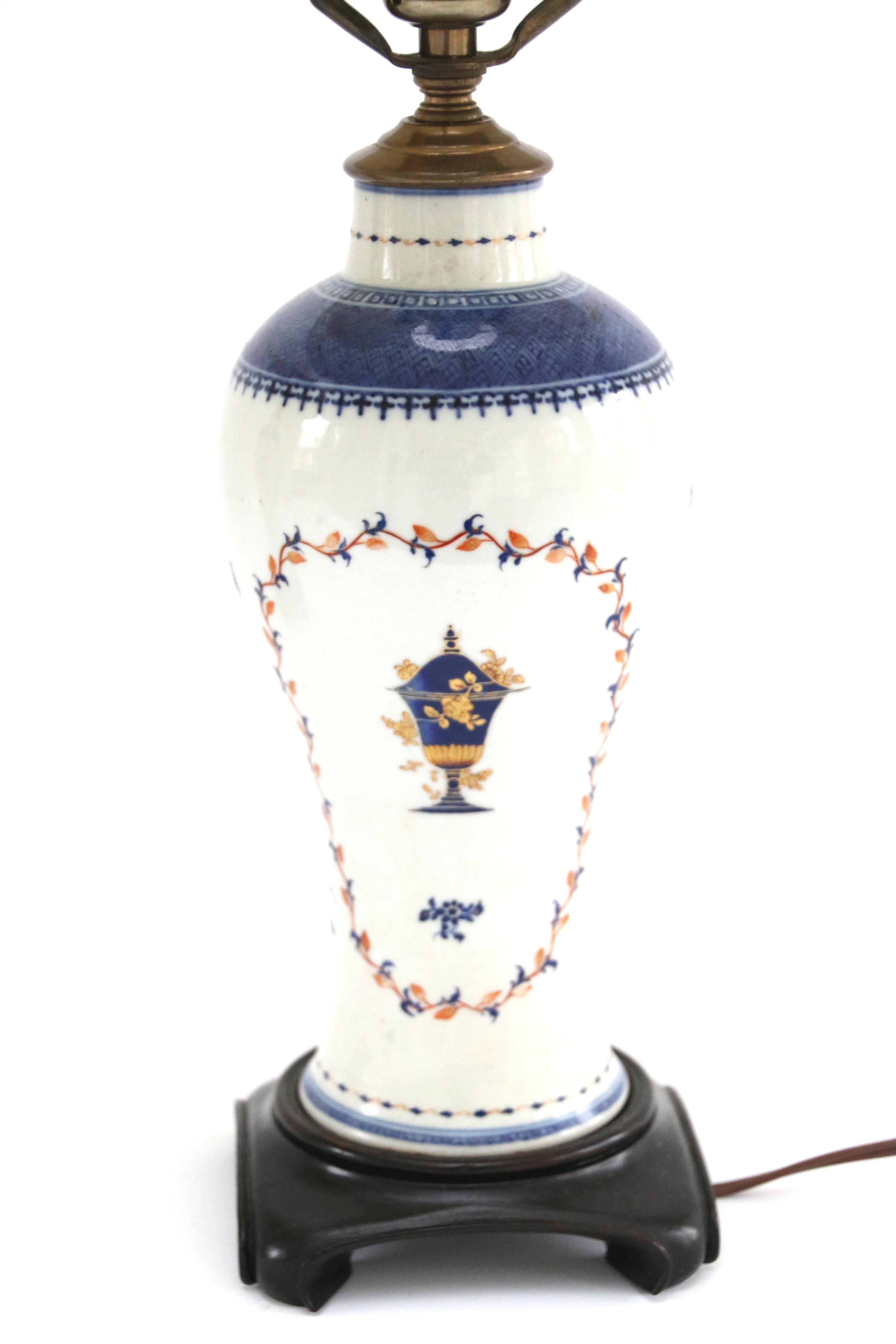 Pair of 18th century Chinese porcelain baluster-form vases featuring an urn and vine decoration in blue and gold. Later fitted as lamps on wooden bases. Vases are 9.75 inches tall (11.5 inches with base); height to top of finial is 22.5 inches,