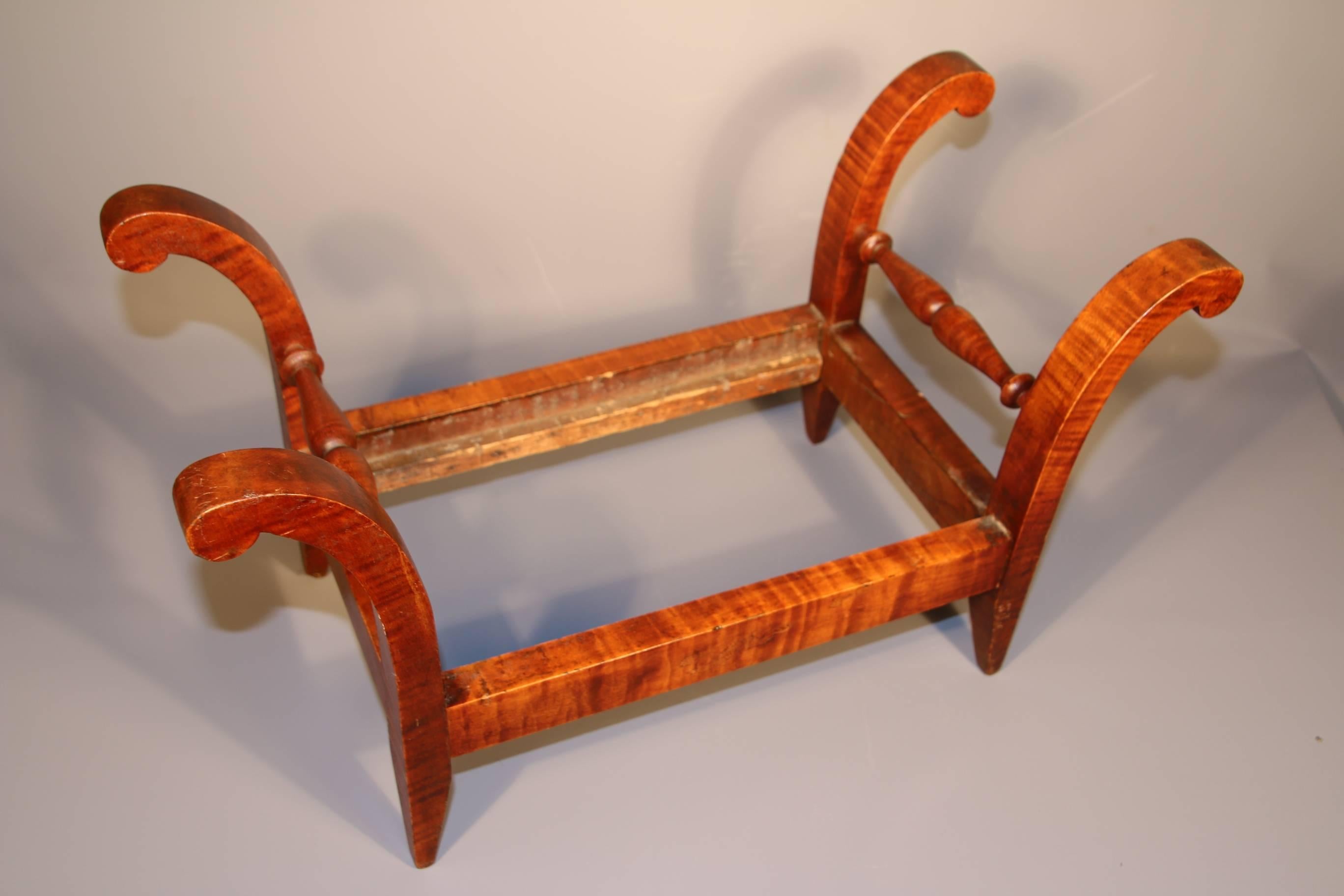 Tiger Maple Footstool, the four scrolled, outward flaring stiles joined by turned medial stretchers on a rectangular seat frame, old surface.

Pennsylvania or New Jersey.

19th Century.

11 ¾”H x 21”W x 10”D