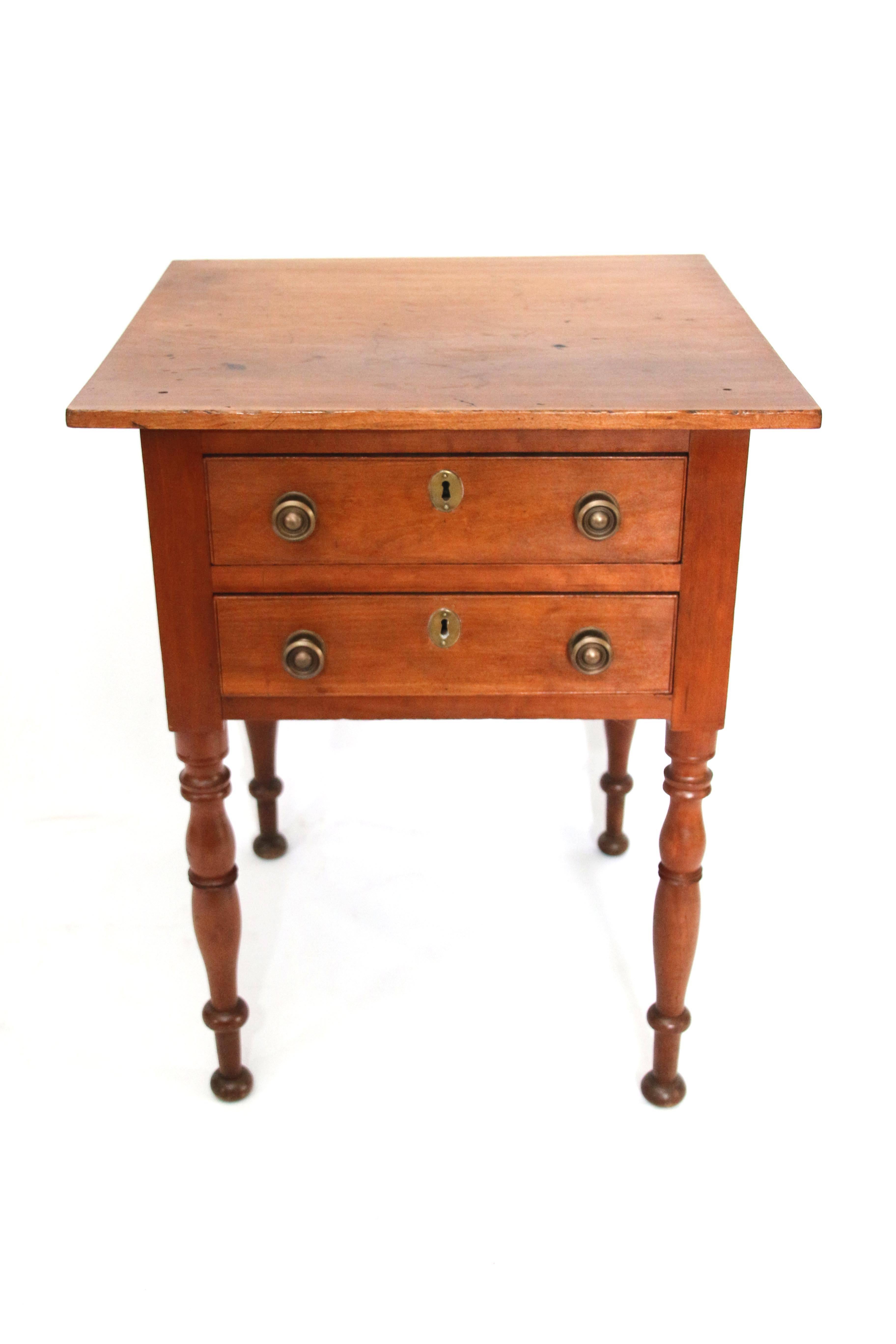 Two-drawer Sheraton cherry work table of generous proportion. Square top with two dovetailed drawers in frieze, each fitted with two brass knobs. All supported by four nicely ring turned legs. 

circa 1825.

Measures: 30” H X 24” W X 23” D.
 