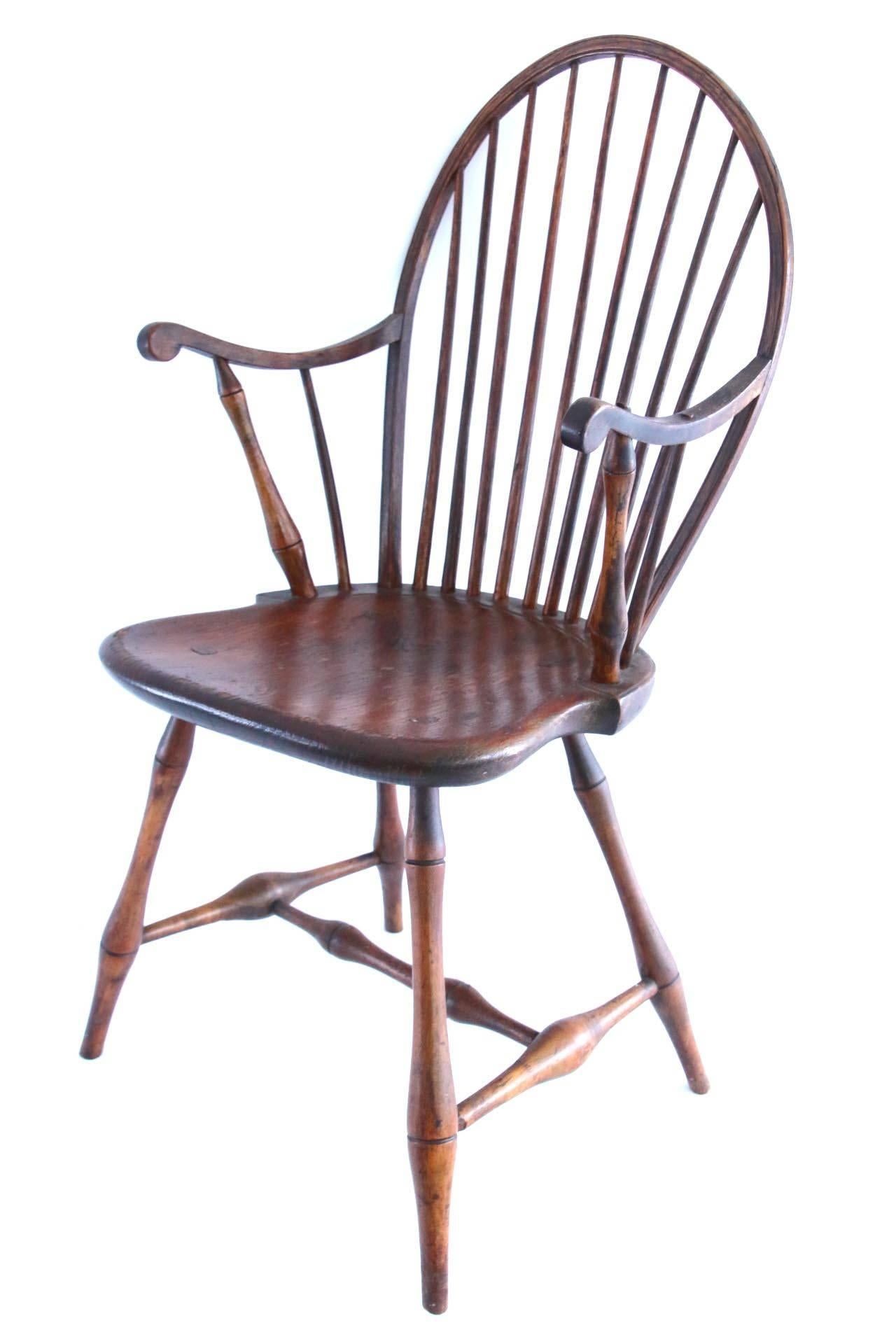 Bowback Windsor armchair with a bowed and incised rail centering a nine-spindle back joined to a shaped seat raised on splayed turned legs joined to a double swell H-form stretcher. 

Massachusetts or Rhode Island, circa 1790. 

Measures: 18 inch;