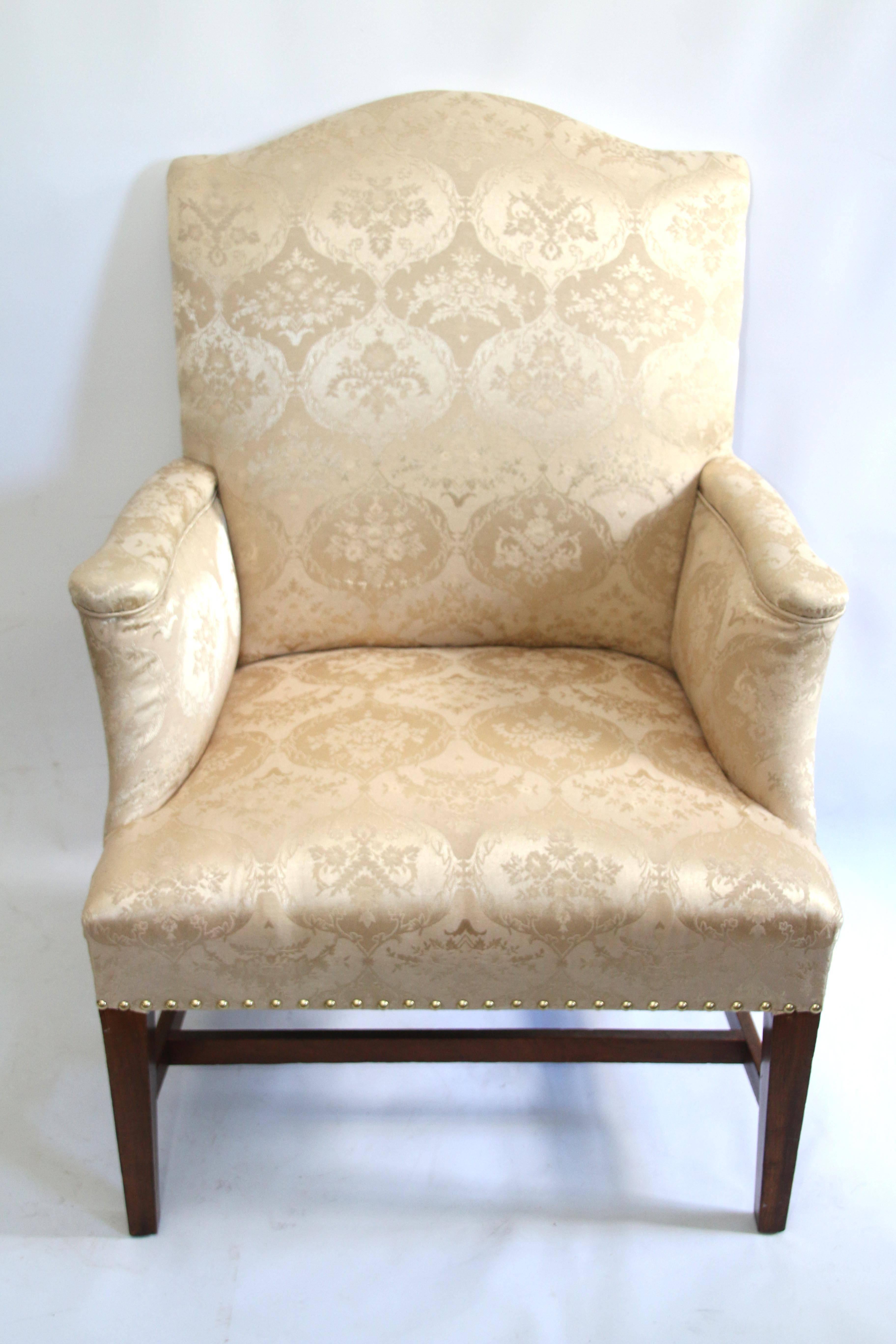 Hepplewhite mahogany side chair with ivory damask upholstery. The rectangular padded back with serpentine crest rail joined to the shaped padded arms, centering the trapezoidal upholstered seat all raised on square tapered front legs and back-swept