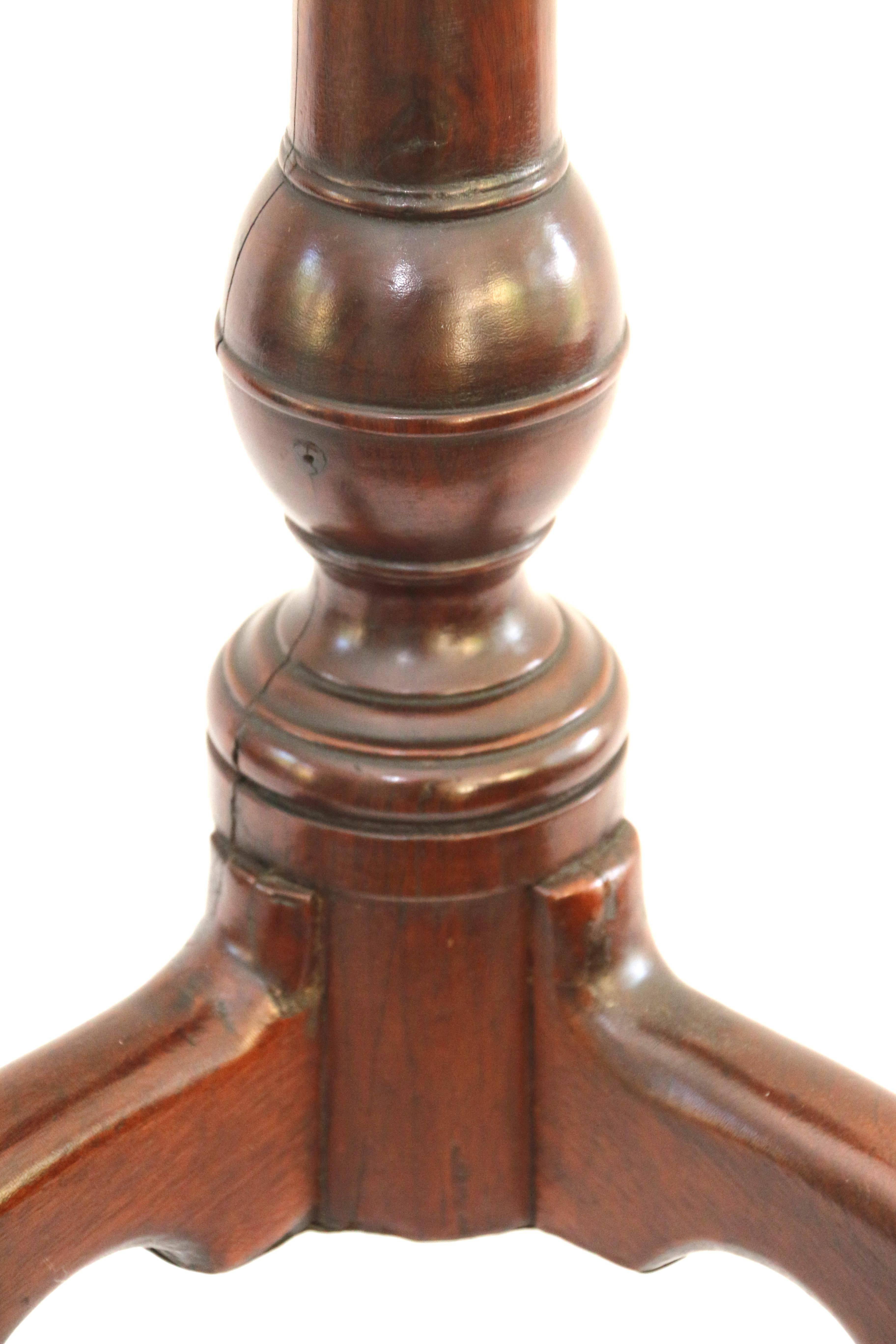 Philadelphia Queen-Anne mahogany dish-top tilt-top birdcage candlestand, the circular top with molded edge tilting above a bird-cage support and raised on a turned standard continuing to a tripod base with high arched cabriole legs and snake feet.