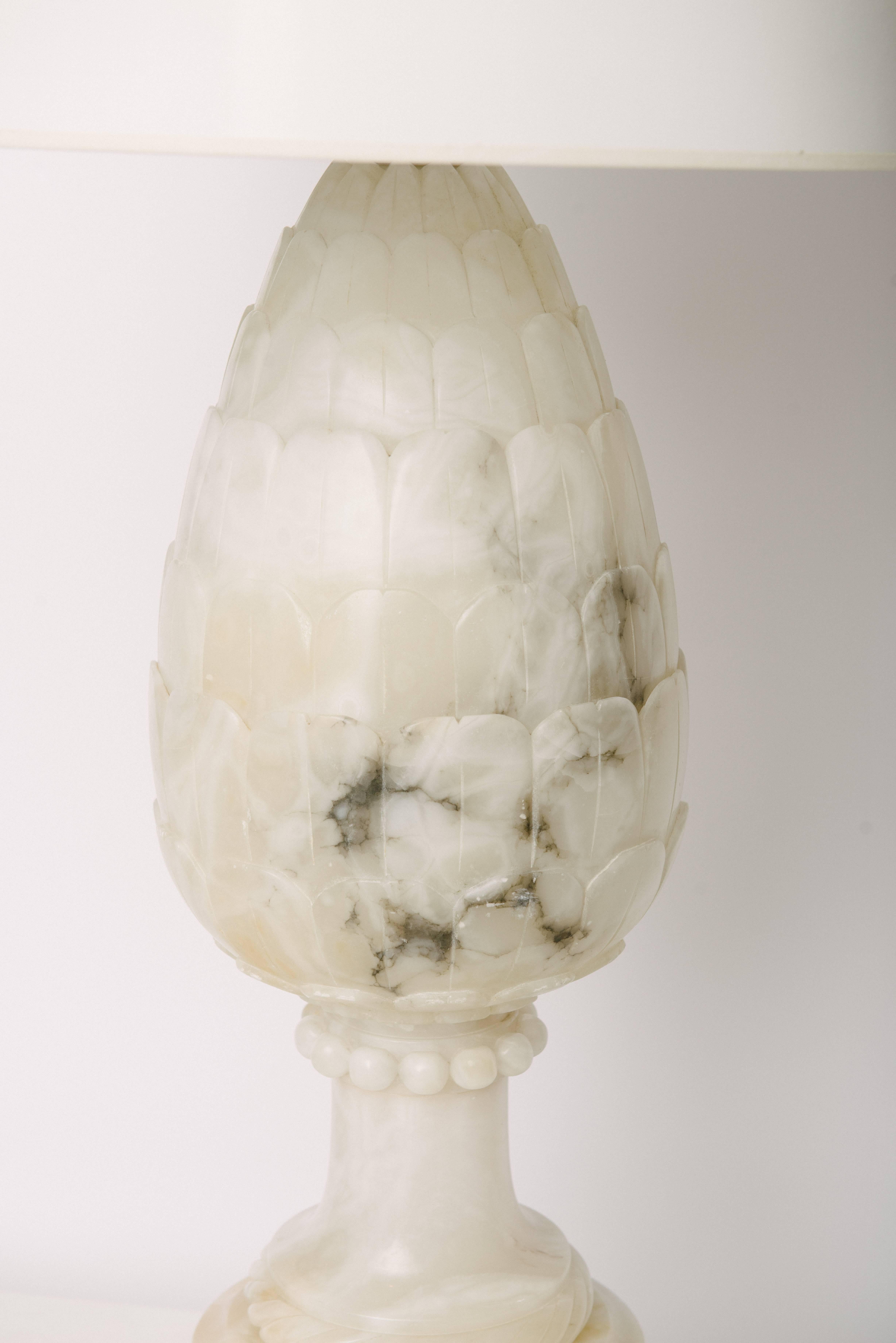 A monumental hand-carved vintage pineapple alabaster lamp by Marbro. This beautiful lamp is a creamy white with gray veining. The gilt lamp base is 11