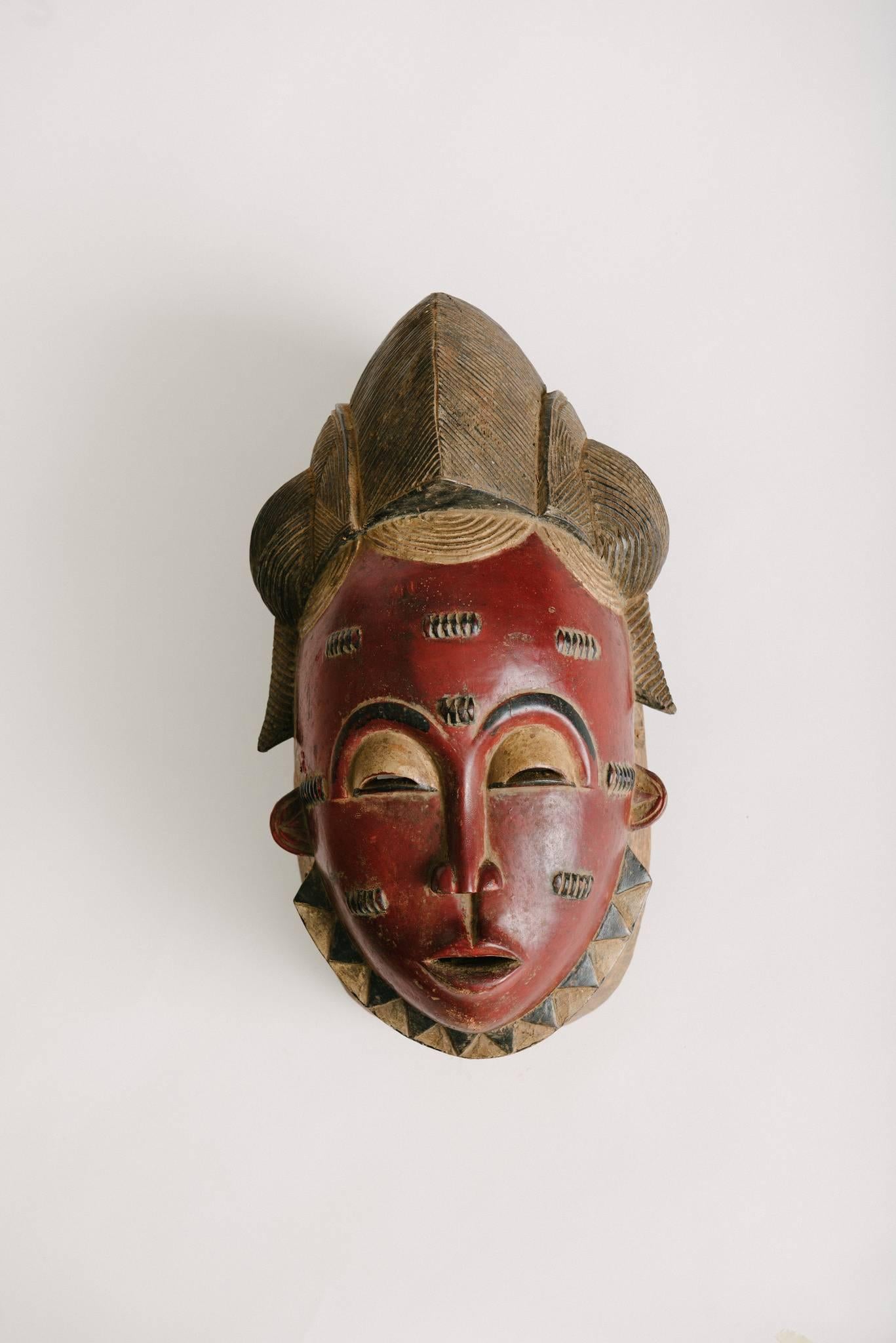 A pair of carved and painted Ivory Coast Gouro male and female tribal masks.