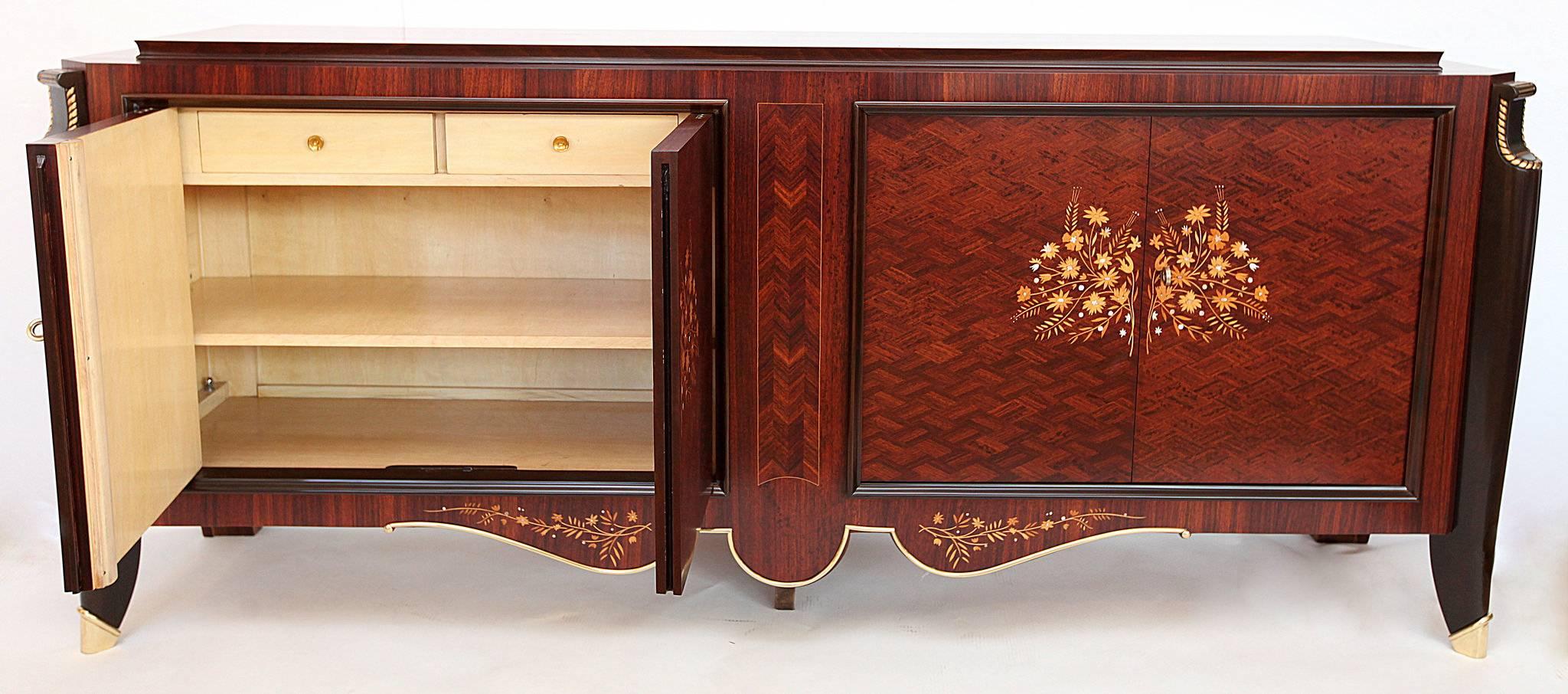 A beautiful Jules Leleu French Art Deco buffet/sideboard with diamond patterned rosewood, walnut supports, satinwood and mother-of-pearl inlay, giltwood edging and raised on bronze sabots. The interior is lemonwood veneer.