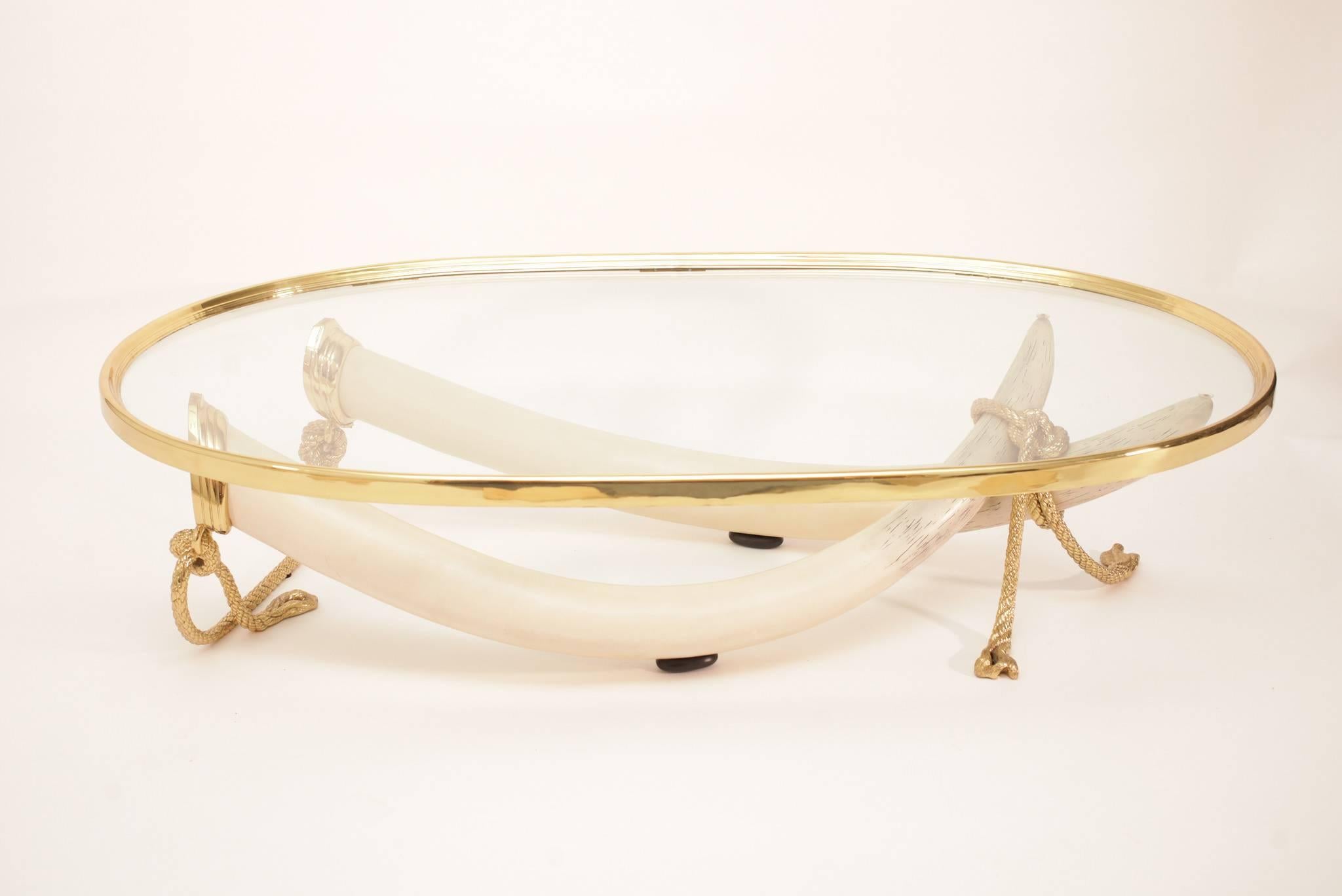 A chic Spanish 1970s signed Valenti faux elephant tusk table with gleaming glass and solid bronze detailing.