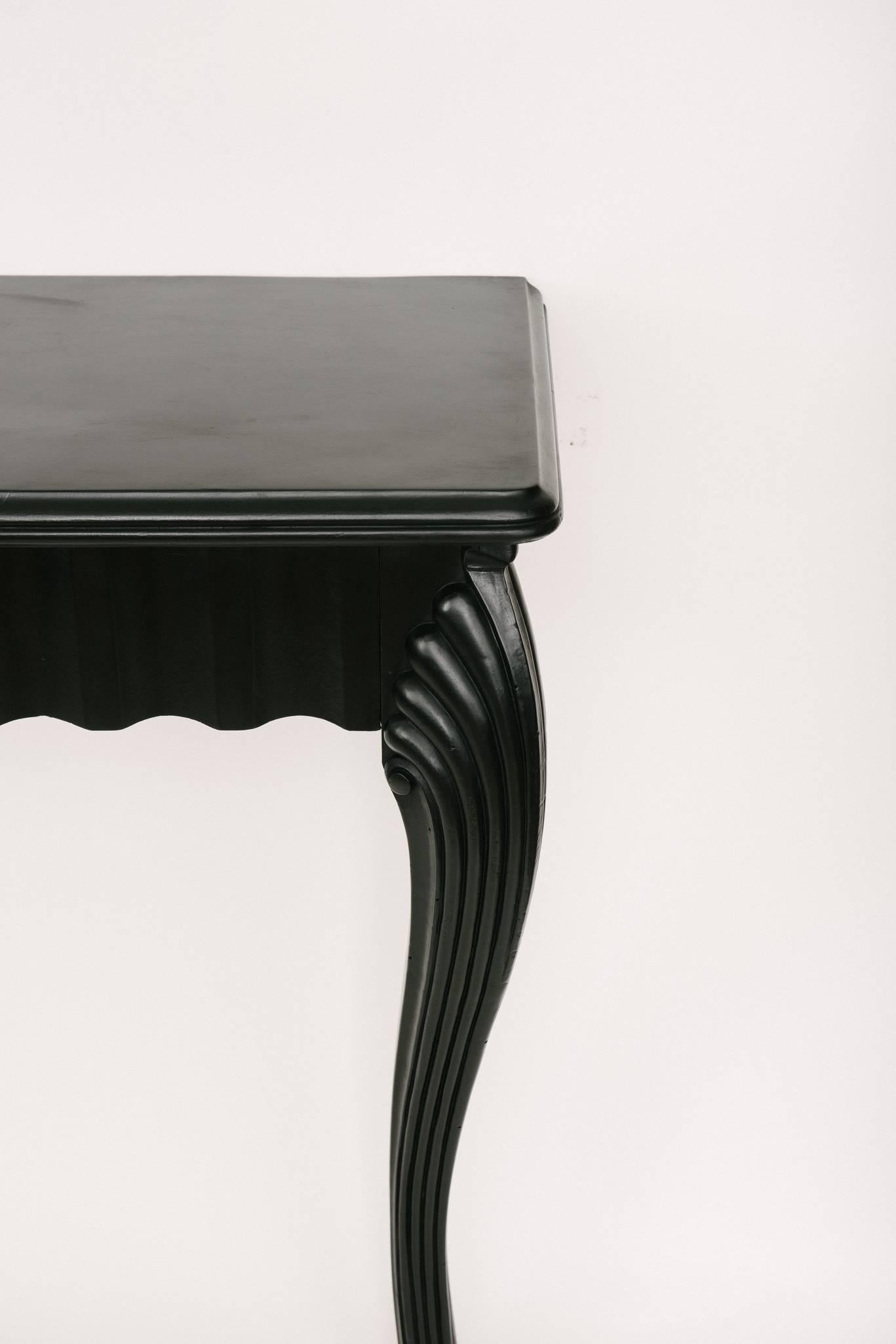 A pair of French ebonized console tables.