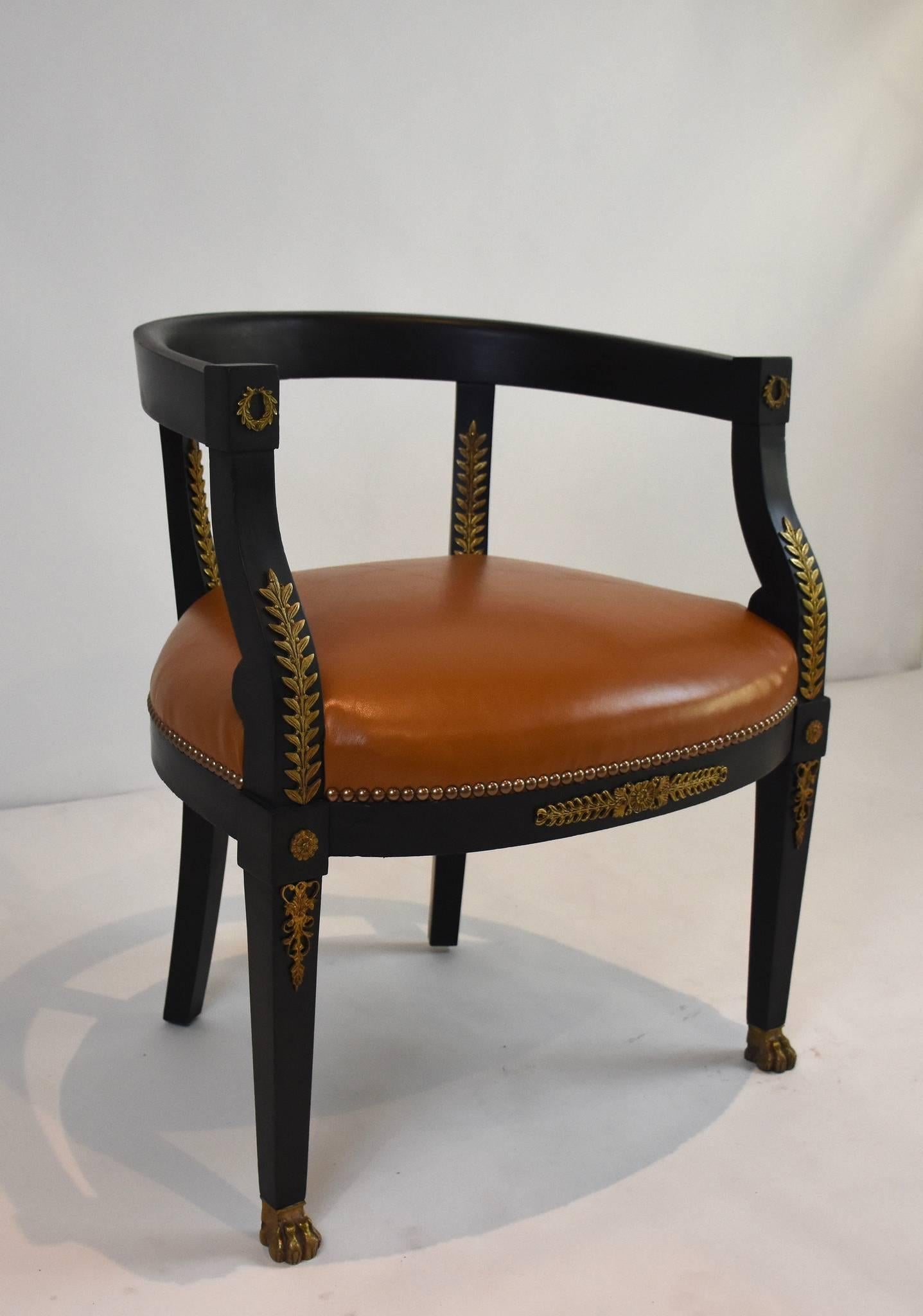 A 19th century Empire Revival black barrel back fauteuil with bronze ormolu and nailhead detail. This chair has been newly upholstered in a cognac goatskin leather and eight-way hand tied springs.