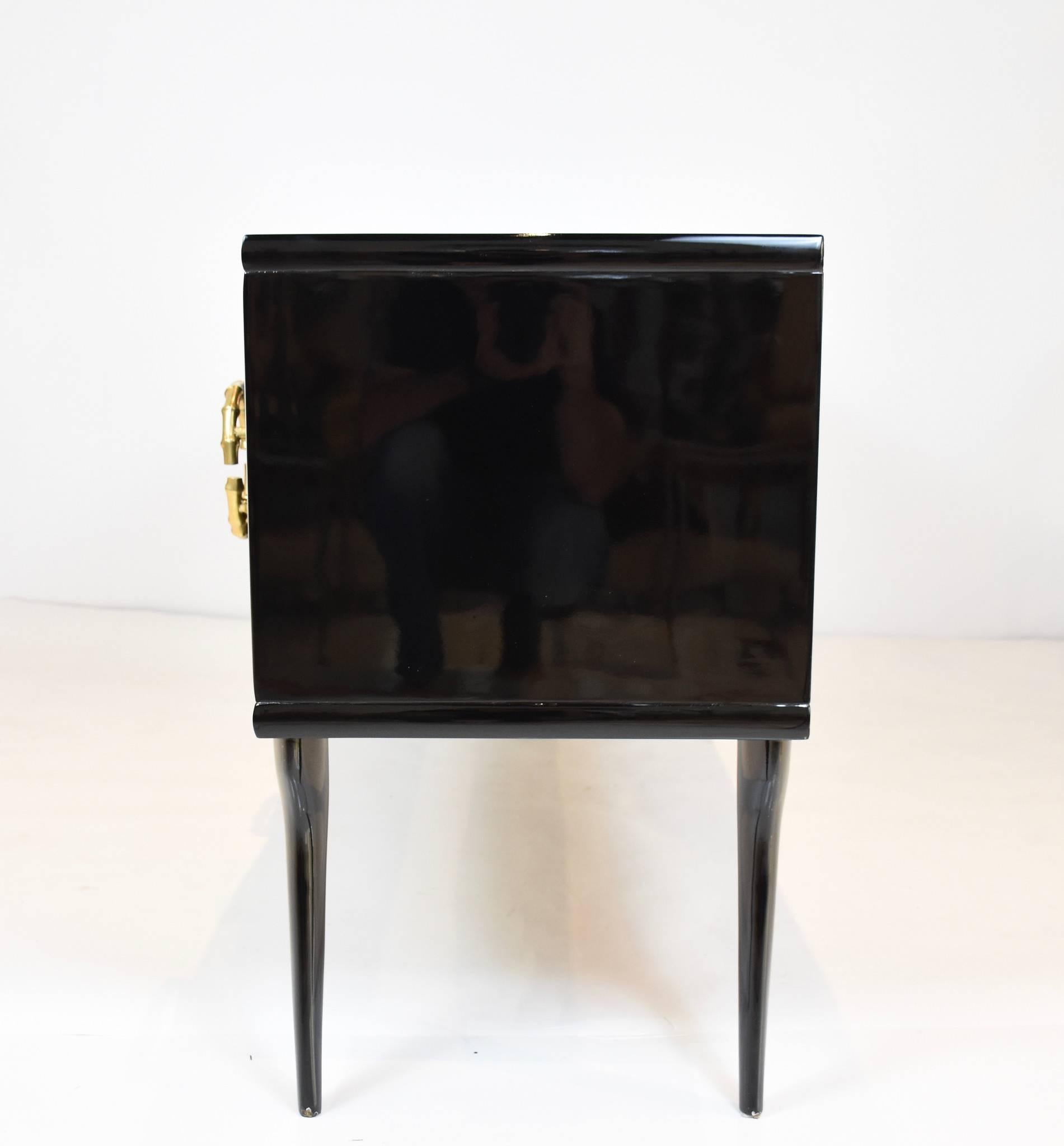 A chic black lacquered six drawer credenza with "gilt bronze" bamboo hardware from Milan, circa 1960s.

Overall dimensions including handles 21.5" D X 67.5" W X 30.5" H
Top dimensions 20" D X 67.5" W.