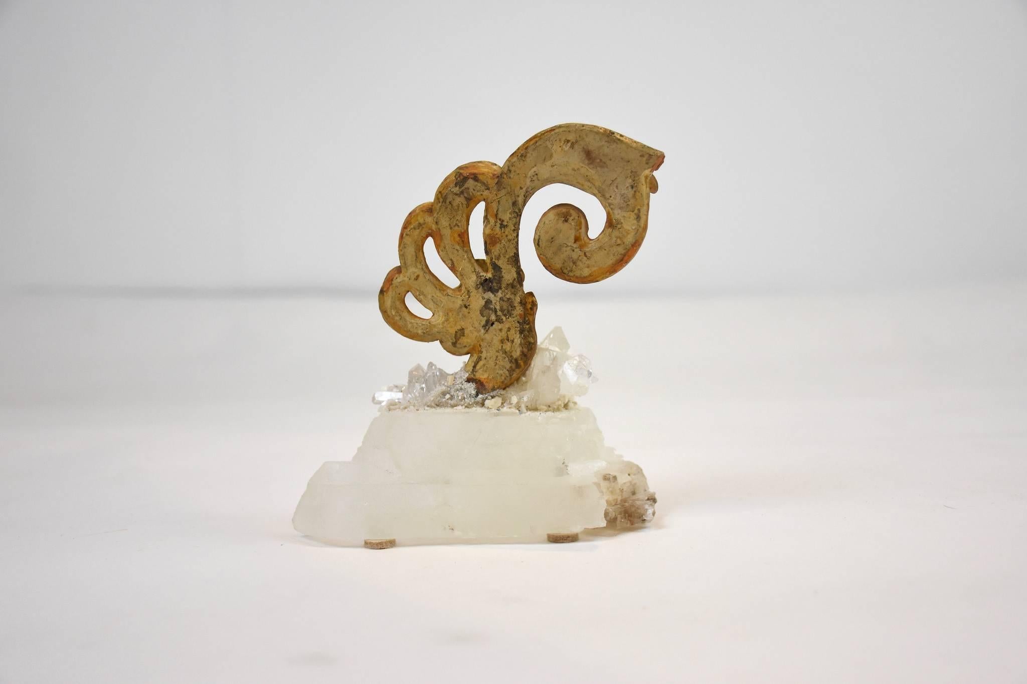 A natural specimen of calcite and quartz are the base for an 18th century Italian giltwood fragment.