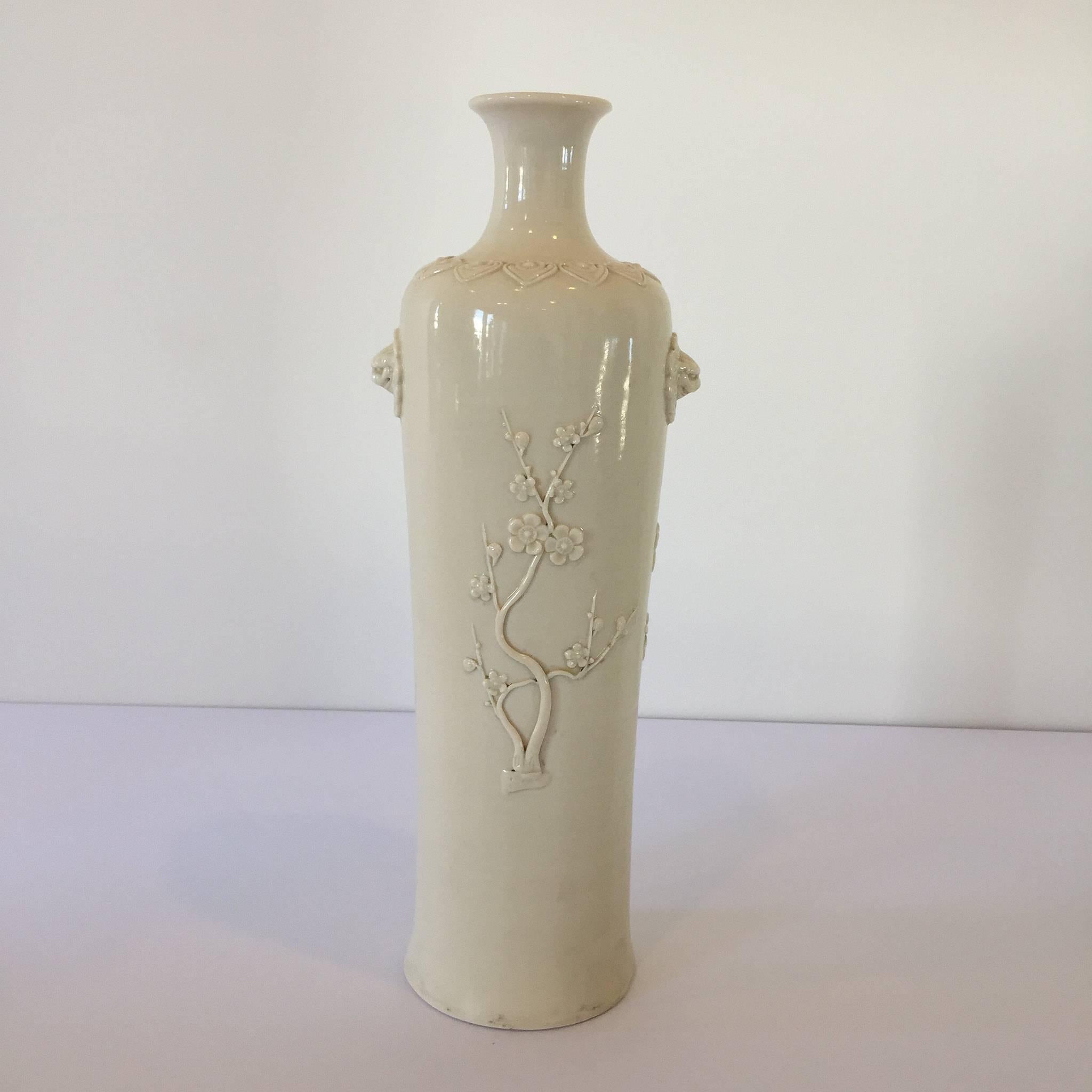A beautiful Chinese Deco white porcelain cherry blossom sleeve vase. This Rolwagen signed vase features cherry blossoms on from and back, mixed foliage/bamboo leaves, and a pair of lion heads.
