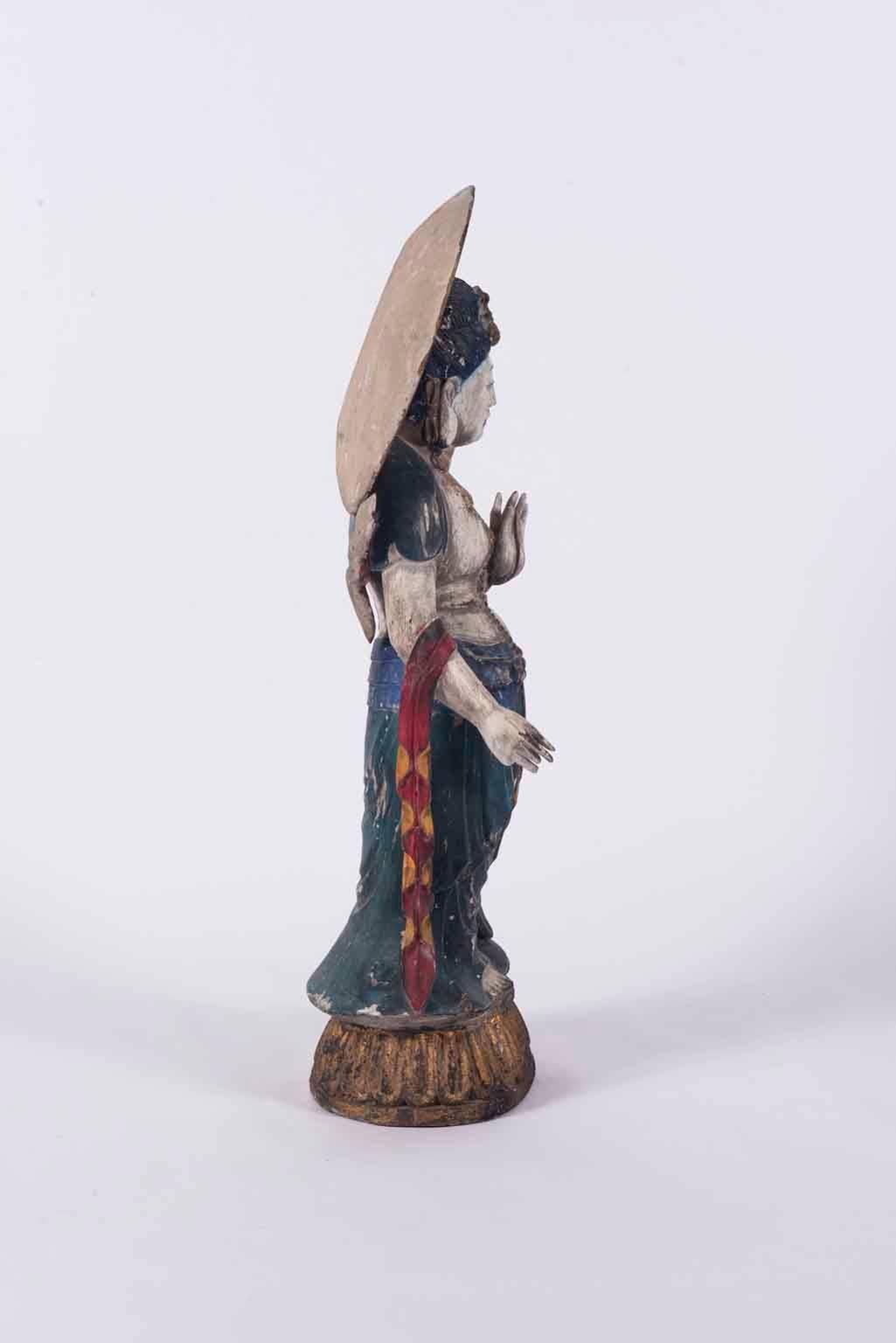 A tall 20th century polychrome carved Asian standing Guan Yin. She is depicted on a lotus pedestal and robed with ribbons and beading, surrounded by a parasol styled moon.