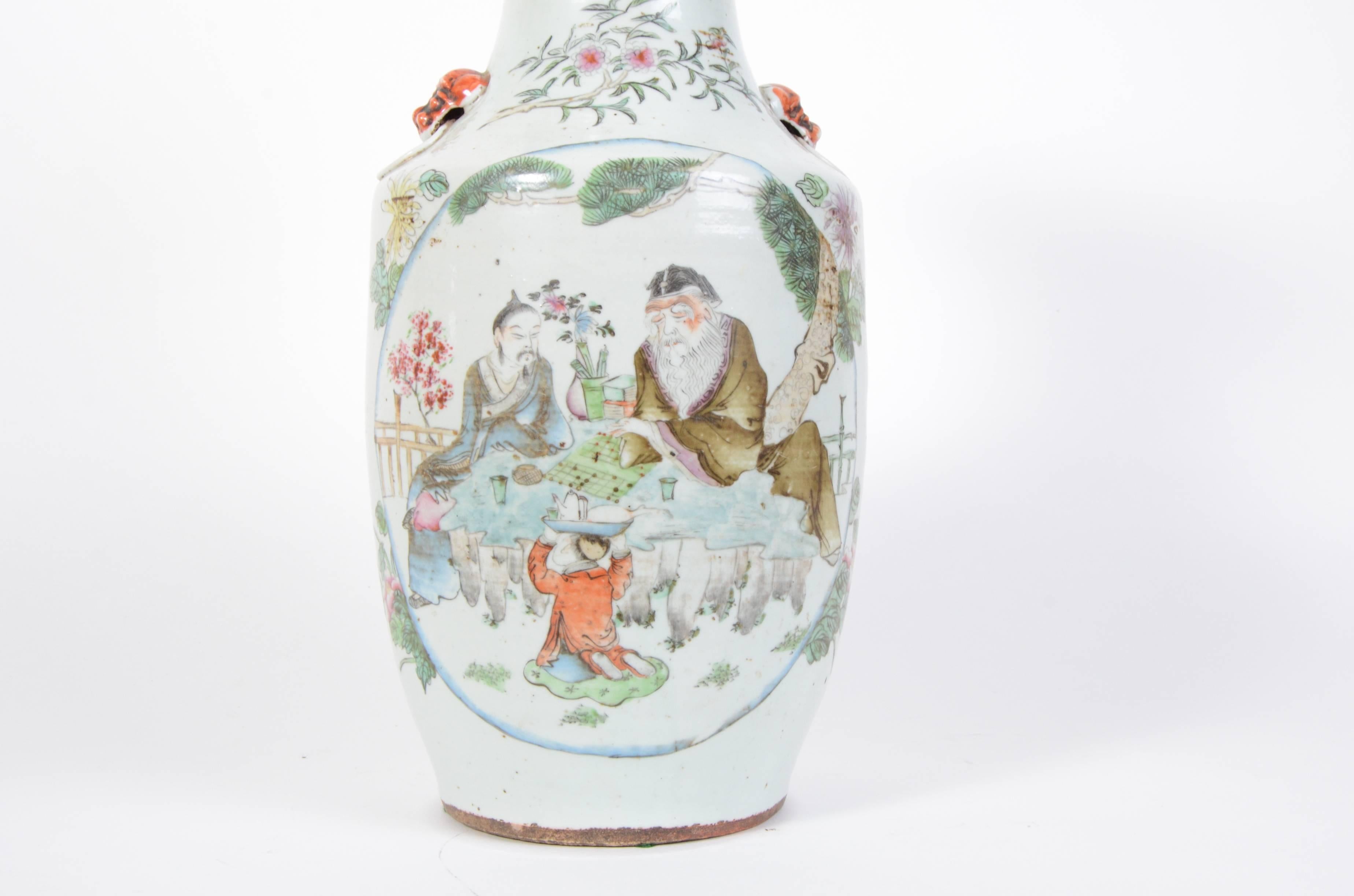 A late 19th century Chinese export porcelain vase. This polychromed scene depicts two-seat scholars or elders with a young servant.