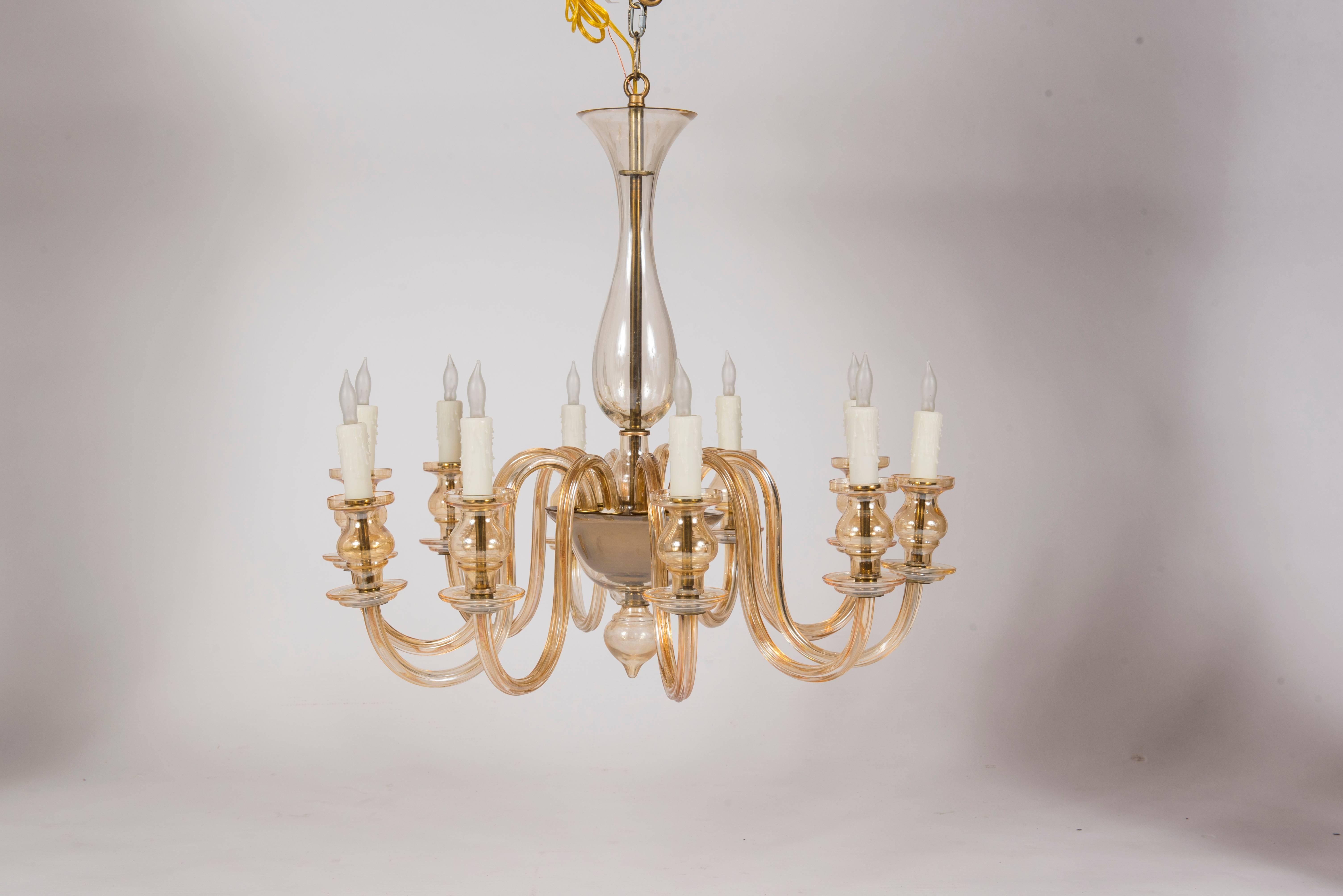 A ten-light Murano glass chandelier. This chandelier is pale amber in coloring with brass detailing. This chandelier is newly electrified and can be easily disassembled for shipping.