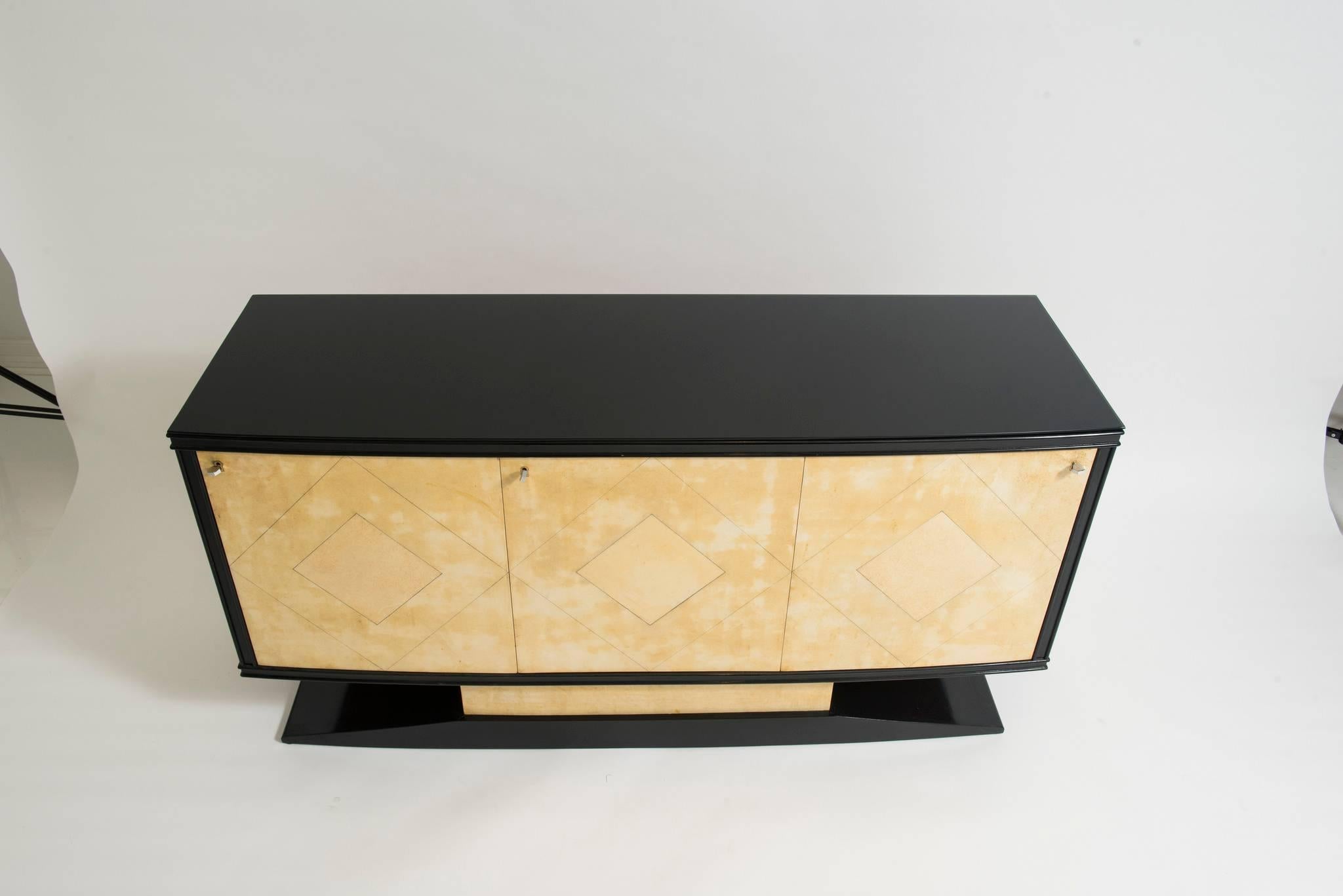 A three-door Art Deco credenza by Vittorio Dassi, Milan, circa 1940s.
This beautiful Maplewood server features four centre drawers, bronze key escutcheons and bronze pulls. The cabinet frame and base are black lacquered topped with a piece of black