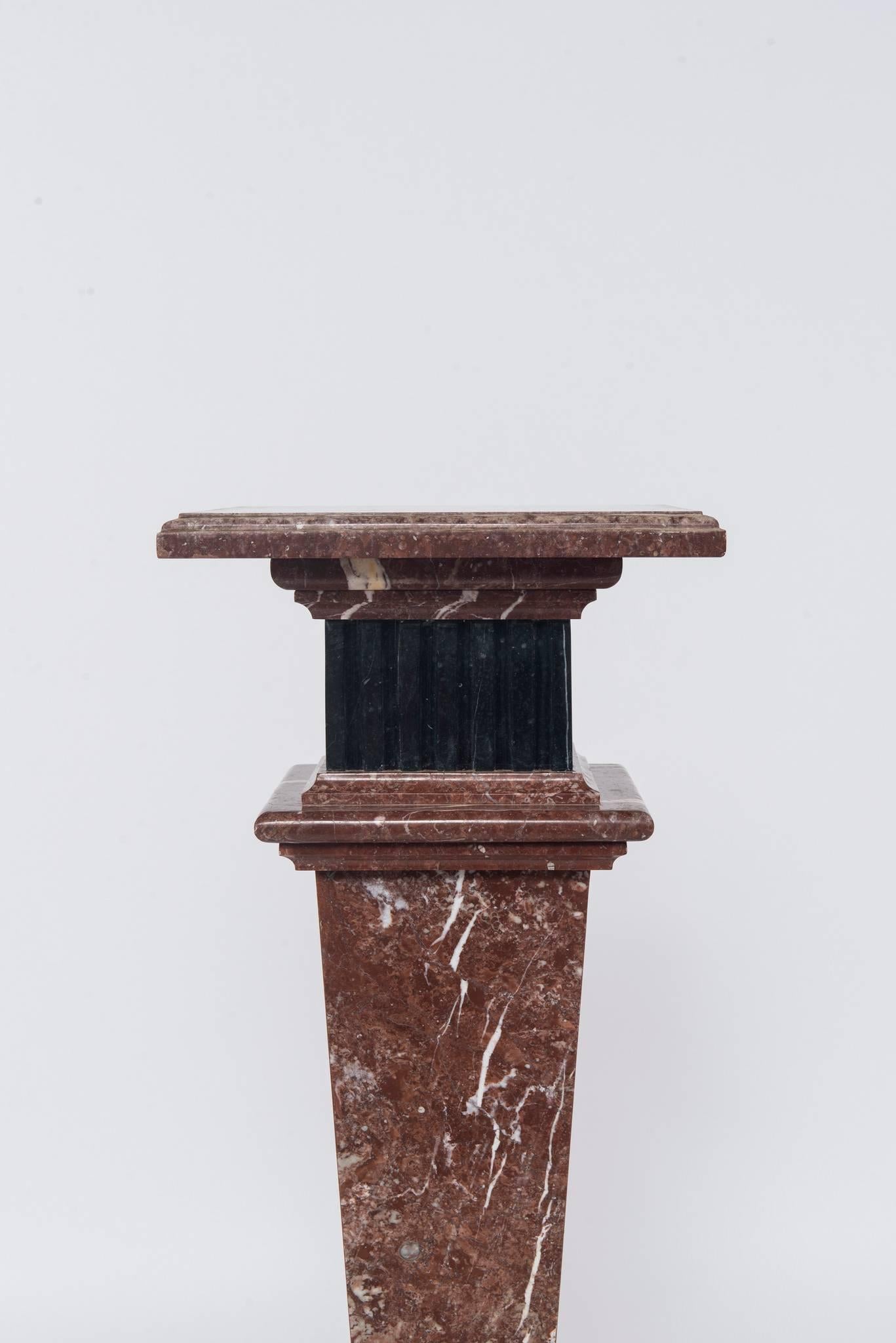 An early 20th century neoclassical style red or rouge and black marble pedestal.