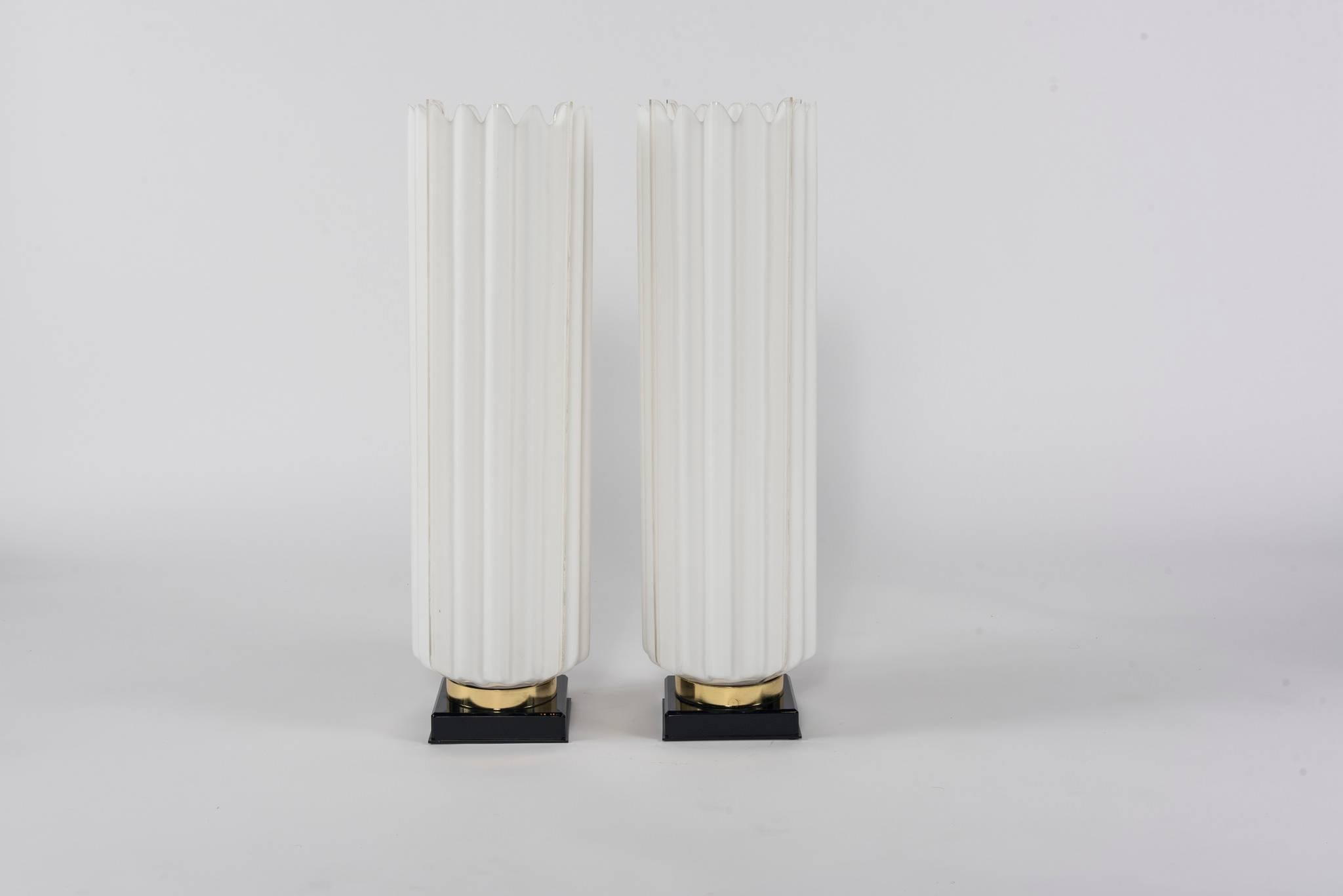 A pair of monumental ruched white acrylic table lamps with brass and black bases, newly electrified.