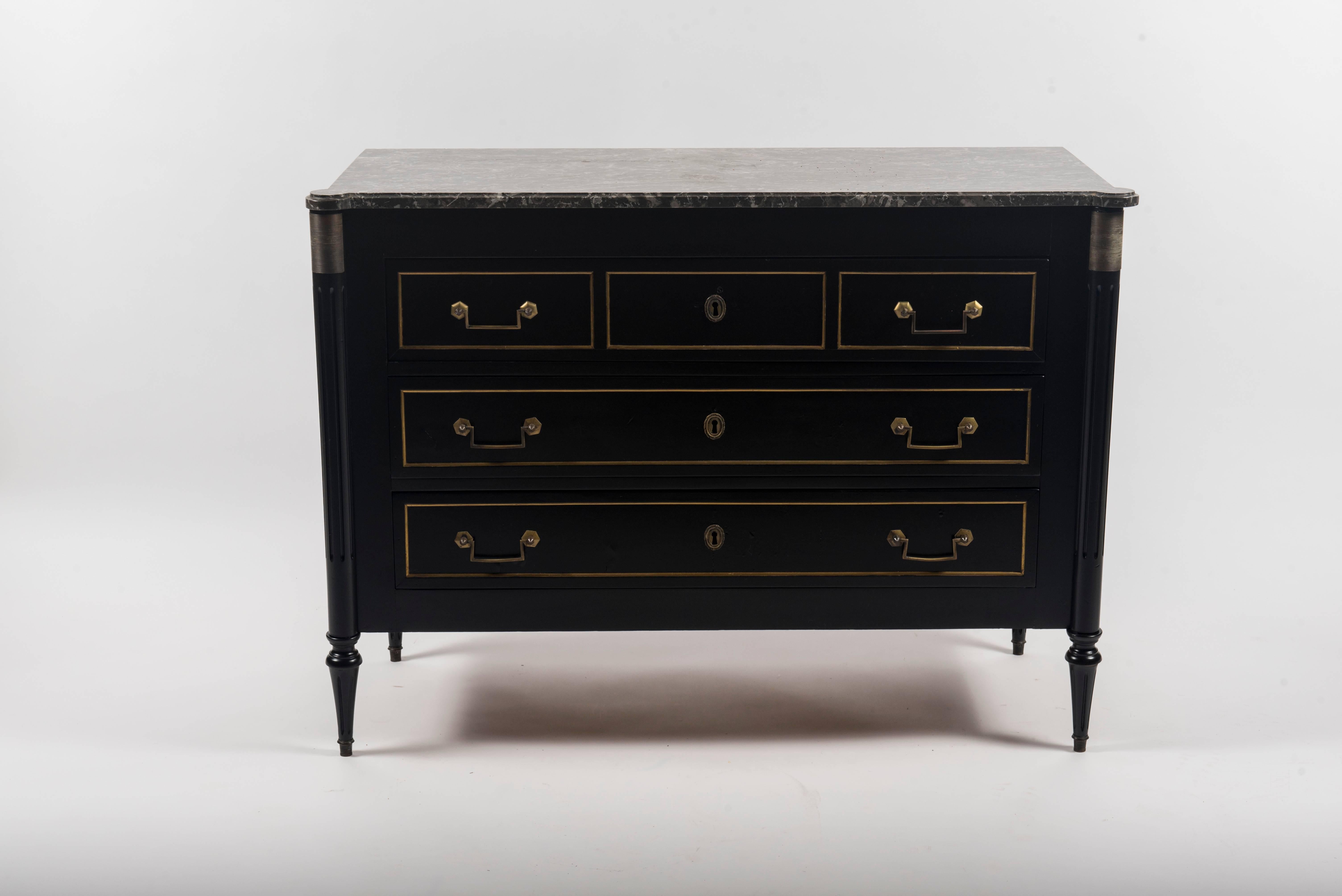 A 1940s, French Maison Jansen style ebonized chest of drawers with bronze handles, trim accents and charcoal gray black marble top.