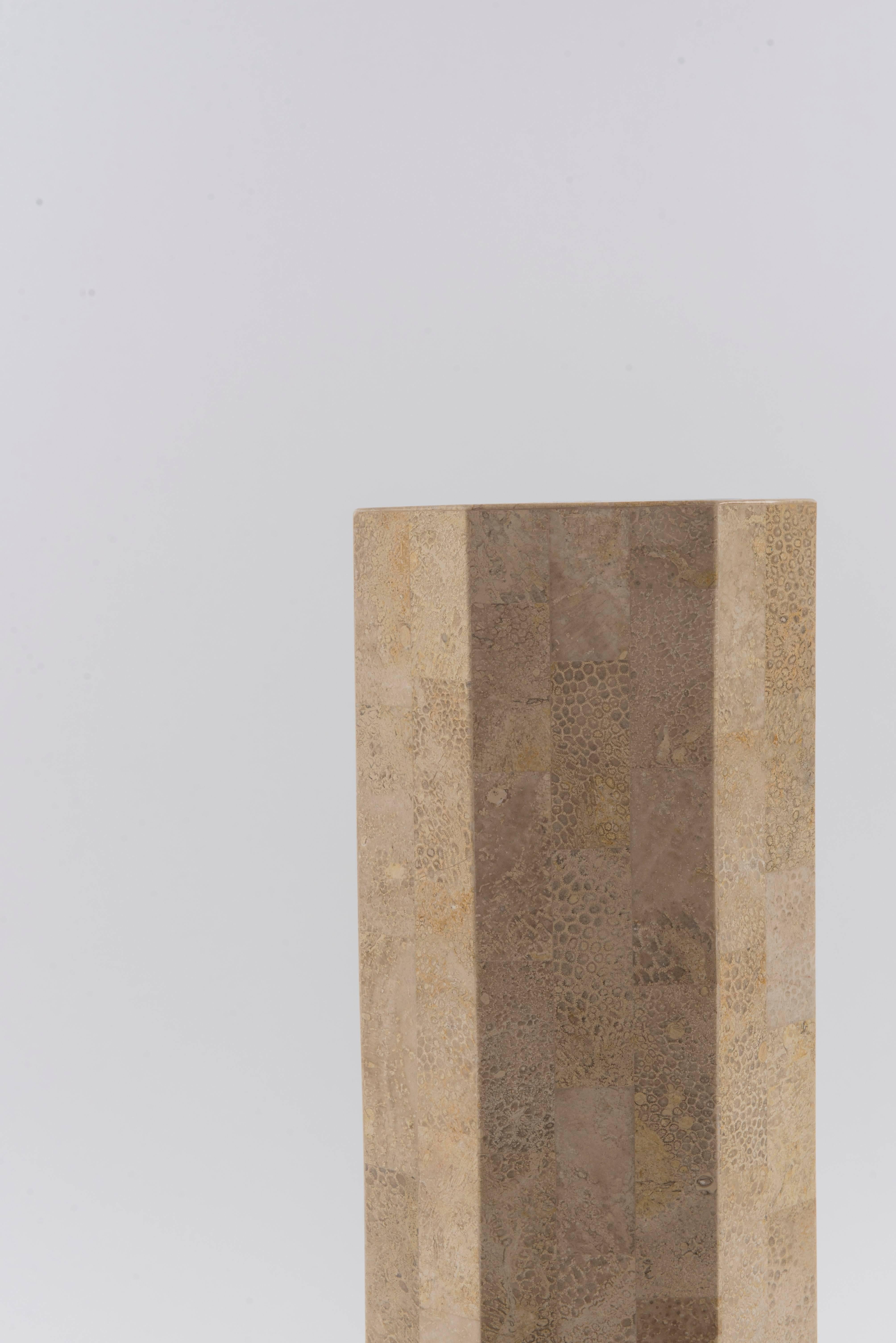 An octagon Maitland Smith style tessellated travertine modern marble pedestal with brass inlay detail and base.