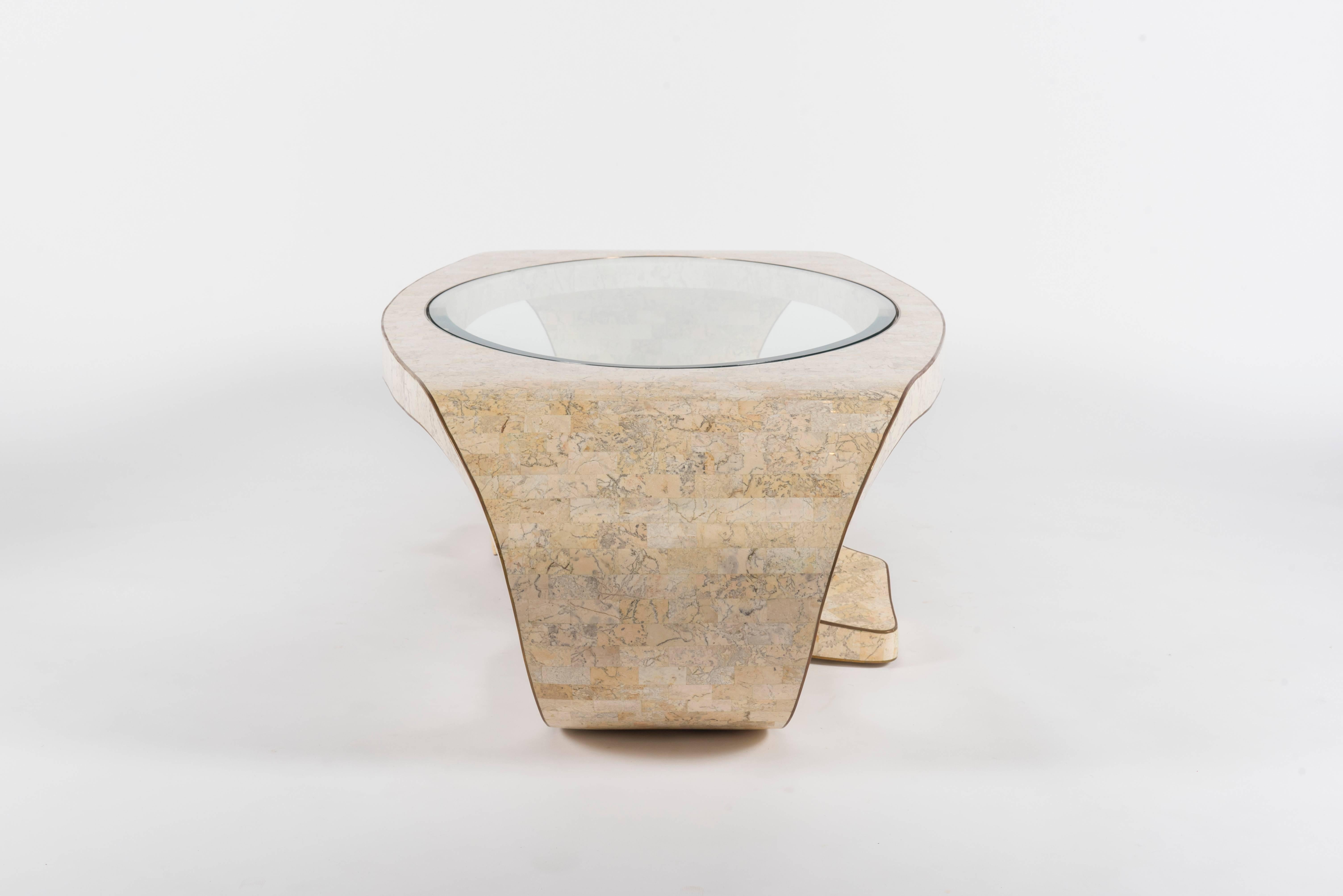 A sculptural cocktail table in tessellated stone with brass inlays and inset glass top by Maitland Smith, 1970s.