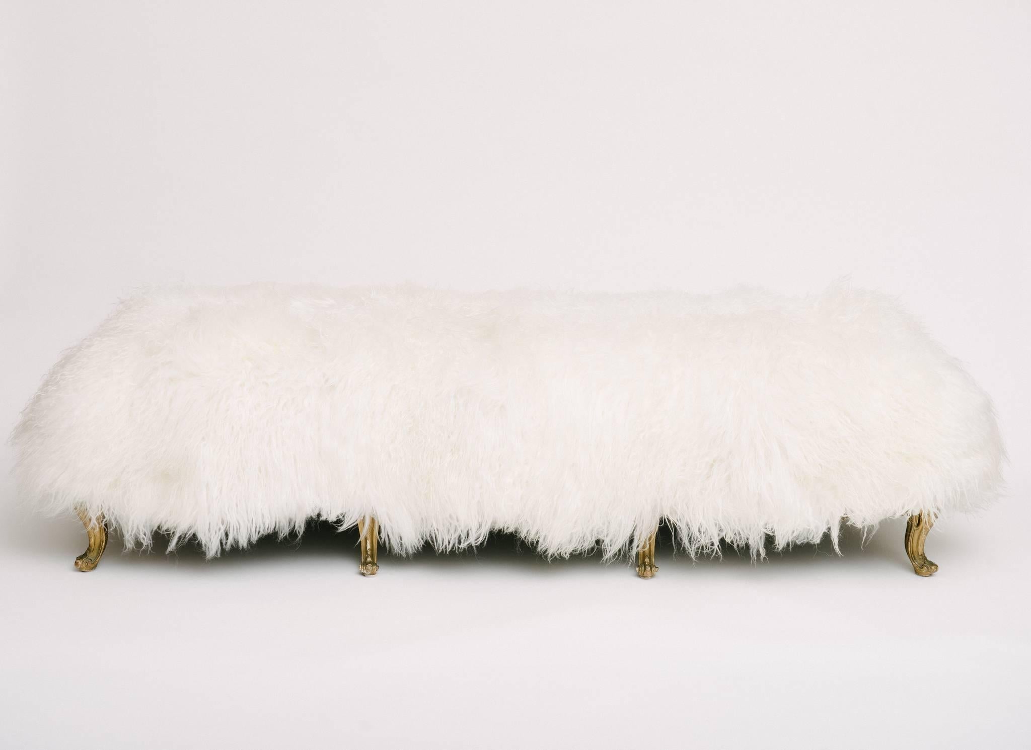 A late 19th century Louis XV style giltwood banquette newly upholstered in longhair Icelandic sheepskin.