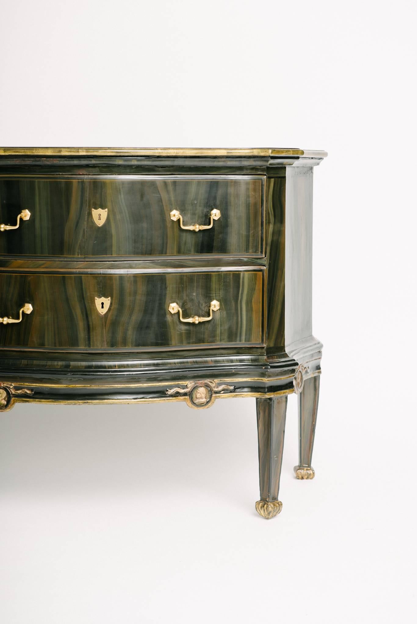 Beautiful Italian painted and gilt two-drawer commode with carved face silhouette detail.