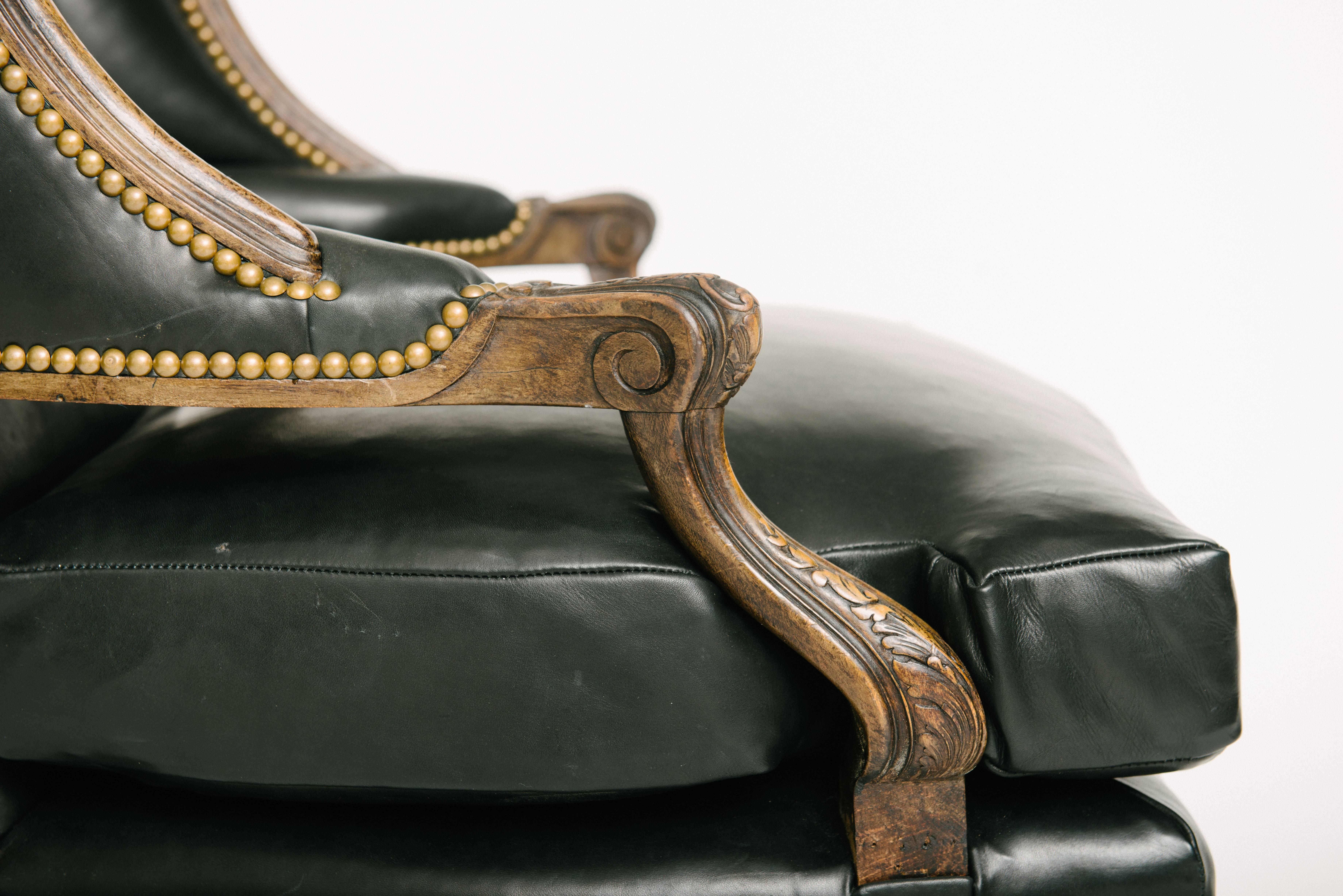 A handsome 19th century Louis XV style en confessional newly upholstered in a luxurious black Italian leather with French nailhead detail.