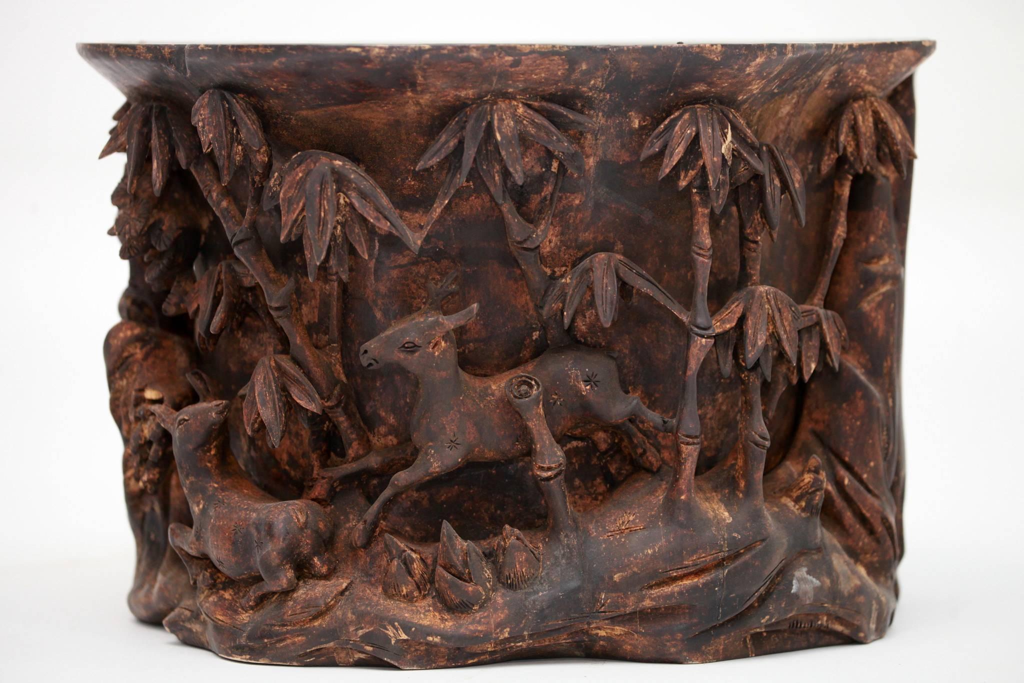 A beautiful and intricately carved Chinese brush pot. This large vessel features beautiful birds, deer and mixed foliage to include bamboo.