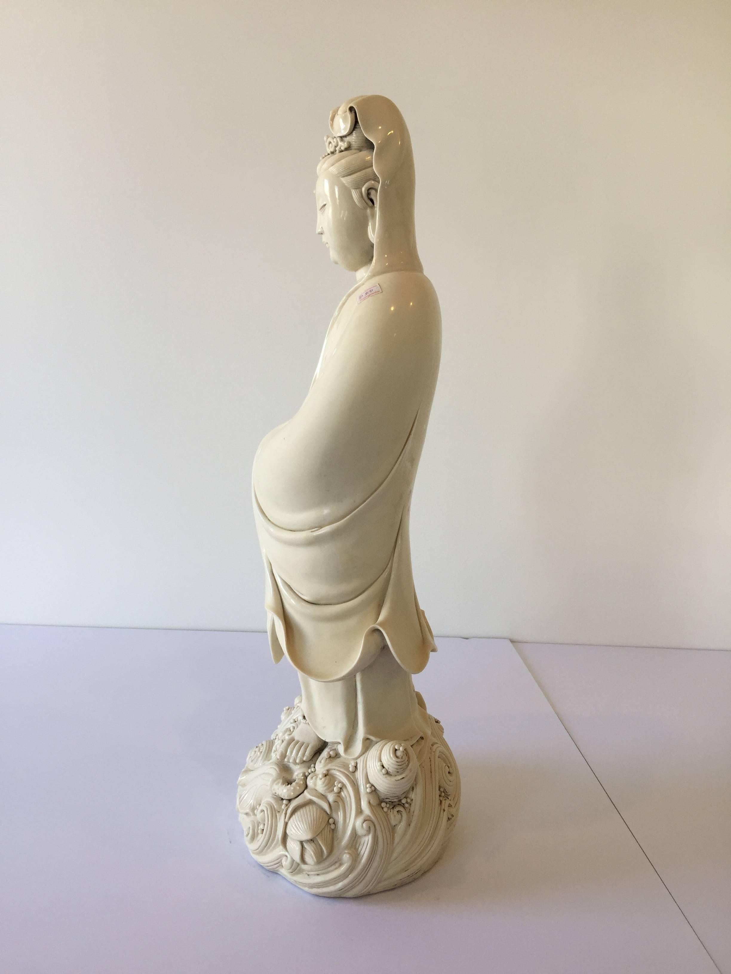 An early 20th century porcelain goddess of mercy on a pedestal of water, shell and lotus features.