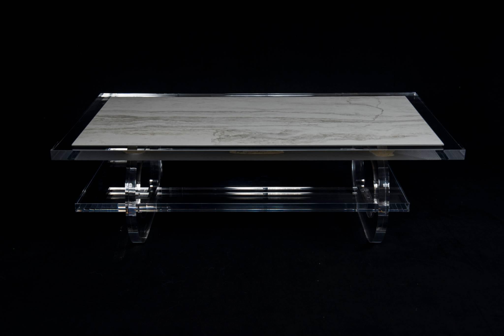 An original G. Ramos newly produced two-tiered Lucite cocktail table with oval racetrack legs. This table features thick Lucite slabbing and a Carrara marble inset top.