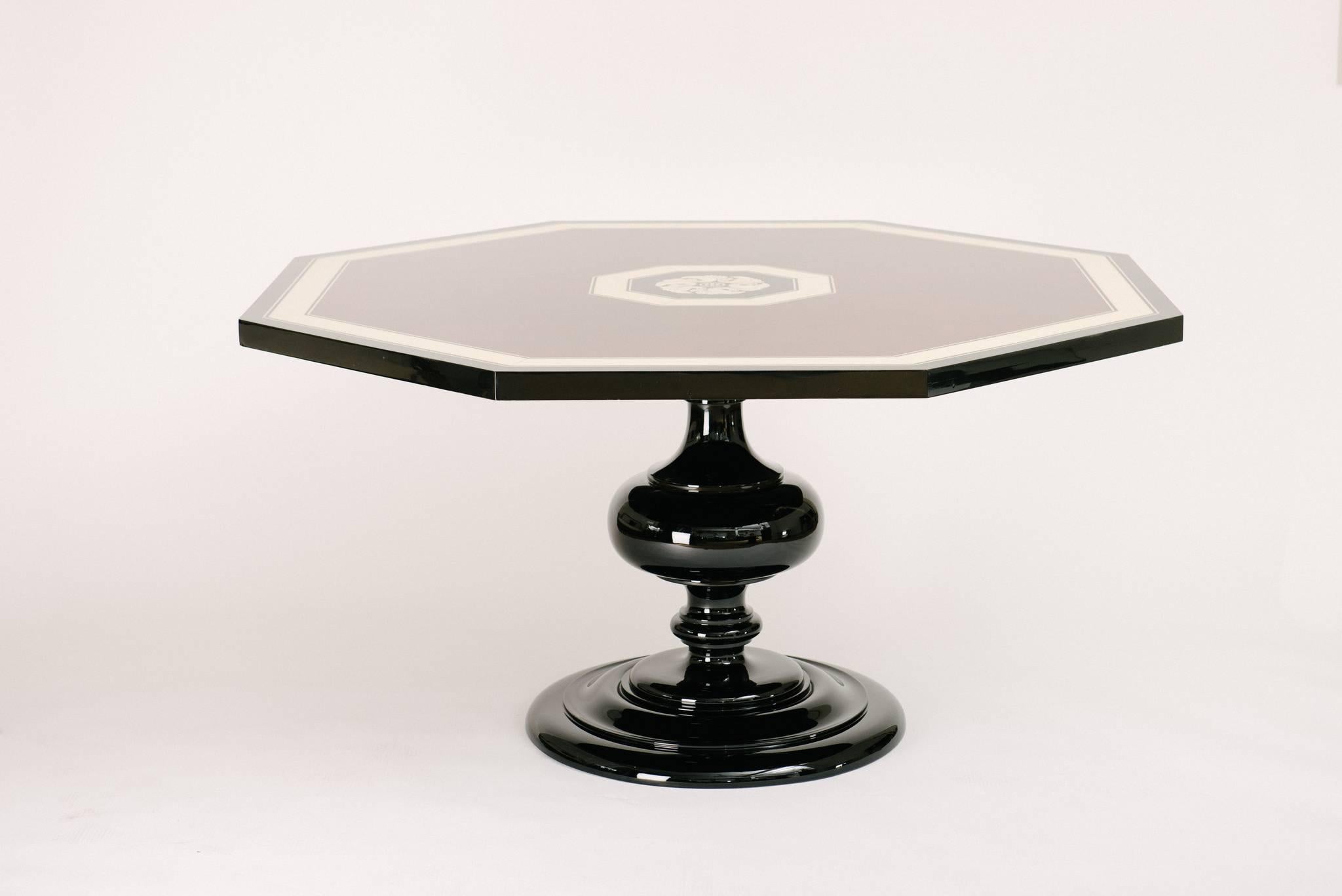 Black lacquer 1940s custom dining or center table with beautiful inlays attributed to ivory and tortoise and a stylized turned pedestal base.

Slight fractures in the lacquer come from the underside due to the shrinkage of the old wood. These