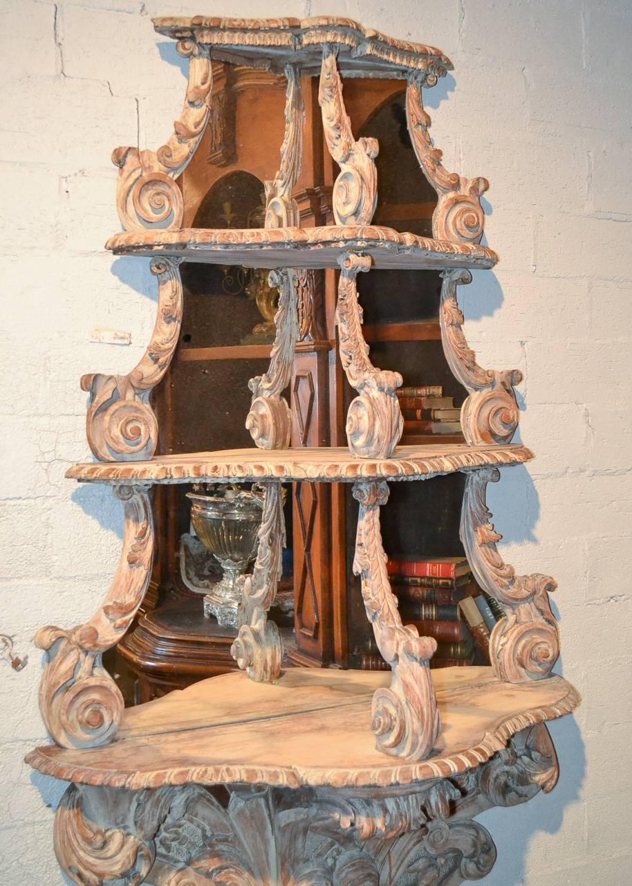 Gorgeous hand-carved and whitewashed hanging etagere with mirrored back, circa 1880. Having wonderfully carved frame in acanthus leaf motif, three tiers of shelves with mirrored backs and alluring patina. 

