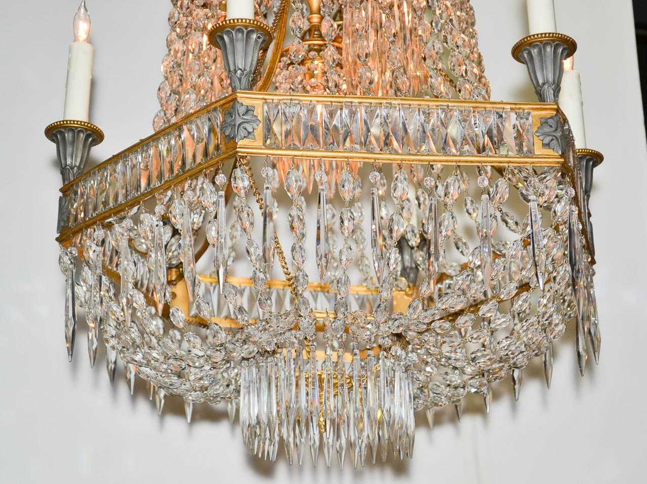Elegant 19th century French Neoclassical gilt bronze and crystal nine-light chandelier. In basket form; having a clean hexagonal bronze frame punctuated with six candle cups and three interior downward facing lights each ringed with crystal drop