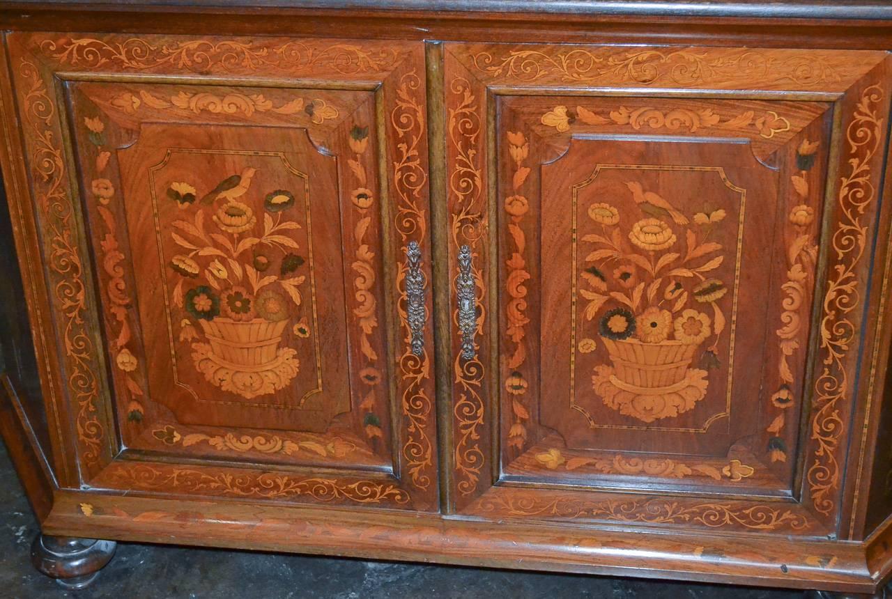 Marvelous Italian credenza with ornate and detailed marquetry inlays. Having doors and sides with inlays in floral and urn motif with various fauna. Exhibiting a rich warm patina.
