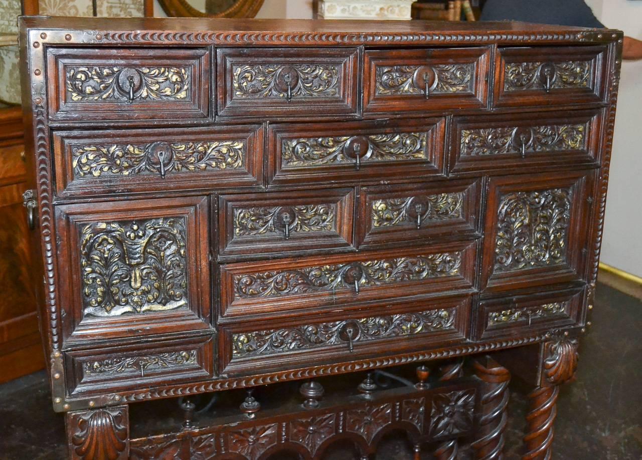 Fantastic 18th century Spanish carved walnut vargueno on stand. Having wonderful carved drawer front in leaf and floral motif and accented with parcel gilt finish. Exhibiting a beautiful aged finish and resting on spiraling legs. 