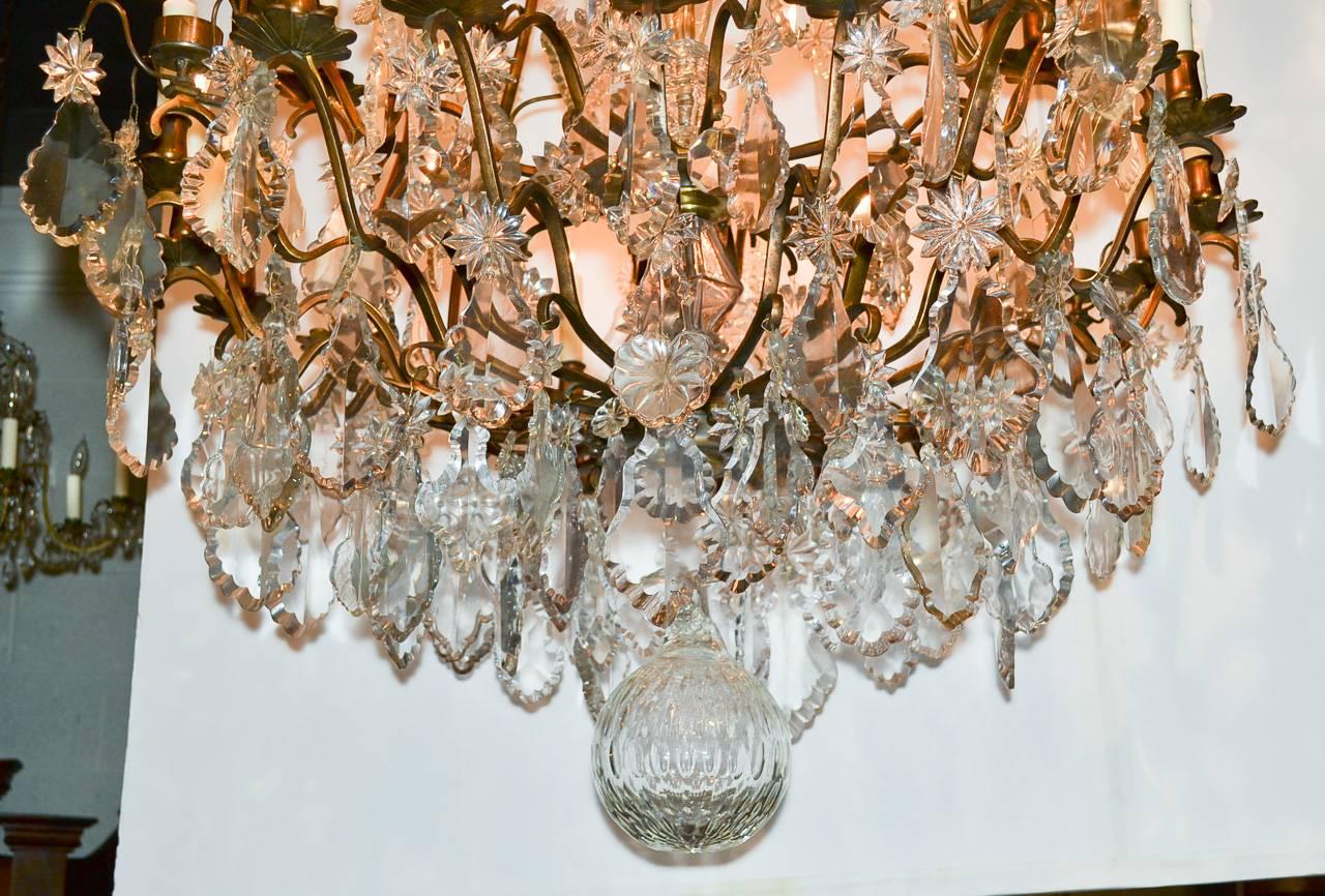 Spectacular French bronze and crystal chandelier with an impressive 35 lights. Having lovely curved frame with two bands of lights with each arm terminating in a floral inspired bobeche. Exhibiting a beautiful central column and wonderfully adorned