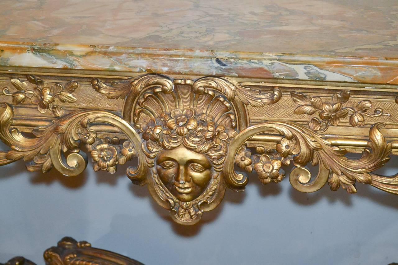 Exceptionally fine 19th century French Regence Style giltwood console with Breche du Benou jaune marble top. Having exquisitely carved frieze with mask and acanthus leaf motif, detailed X-form stretcher and lustrous gilt finish.
                   