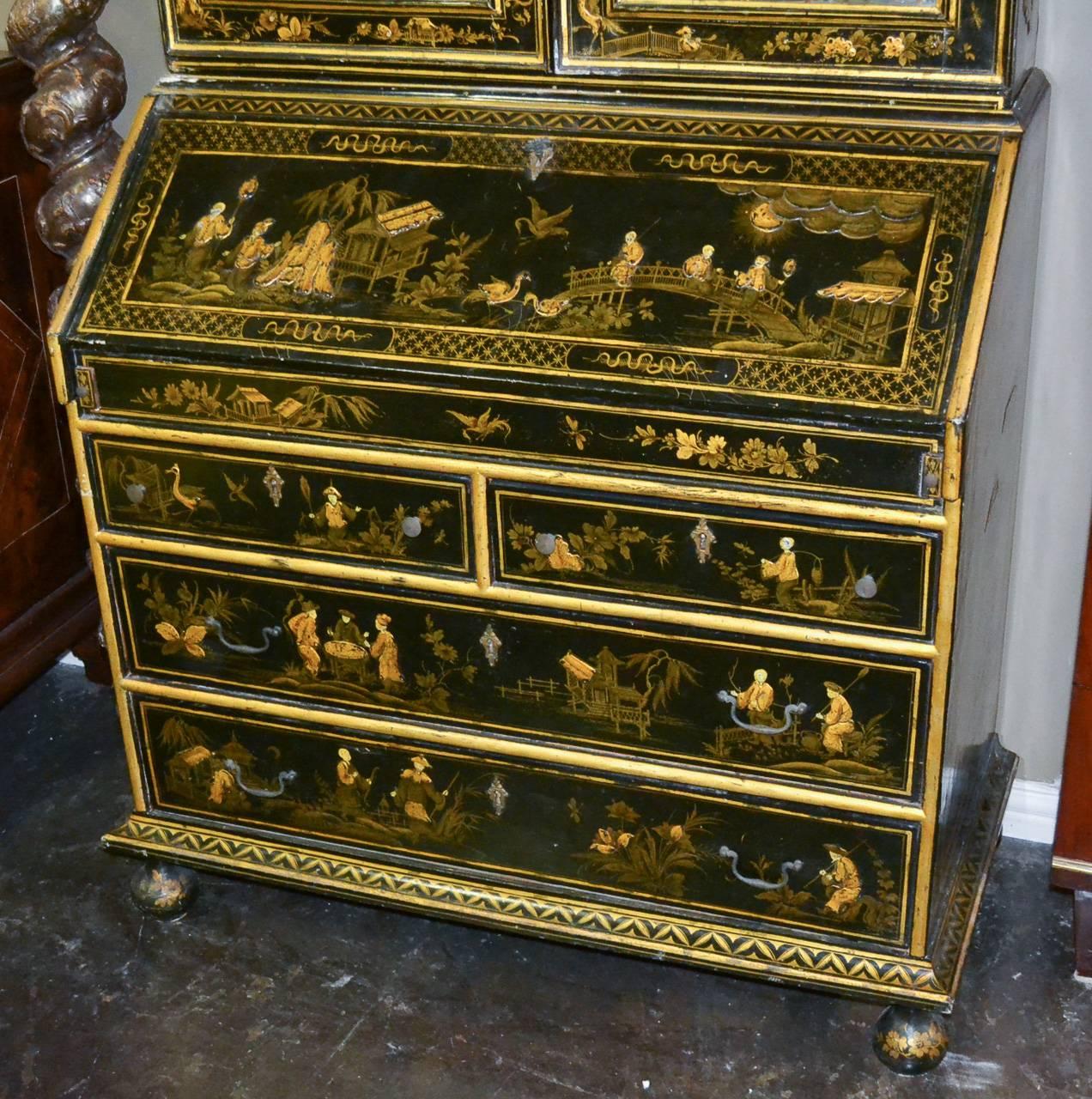Fantastic 19th century English black lacquered chinoiserie five-drawer secretary. Having wonderful oriental scenes with figures and fauna, original beveled mirrored glass in doors, and resting on ball feet. 