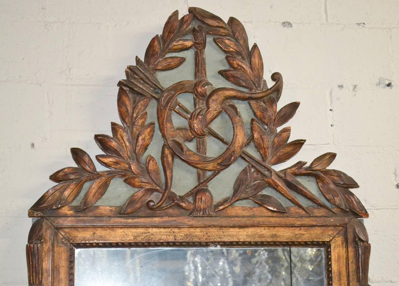 Alluring 19th century Italian hand-carved and parcel-gilt mirror. Having lovely original mercury glass, beautiful cartouche in laurel and arrow motif and wonderful aged patina. 

  